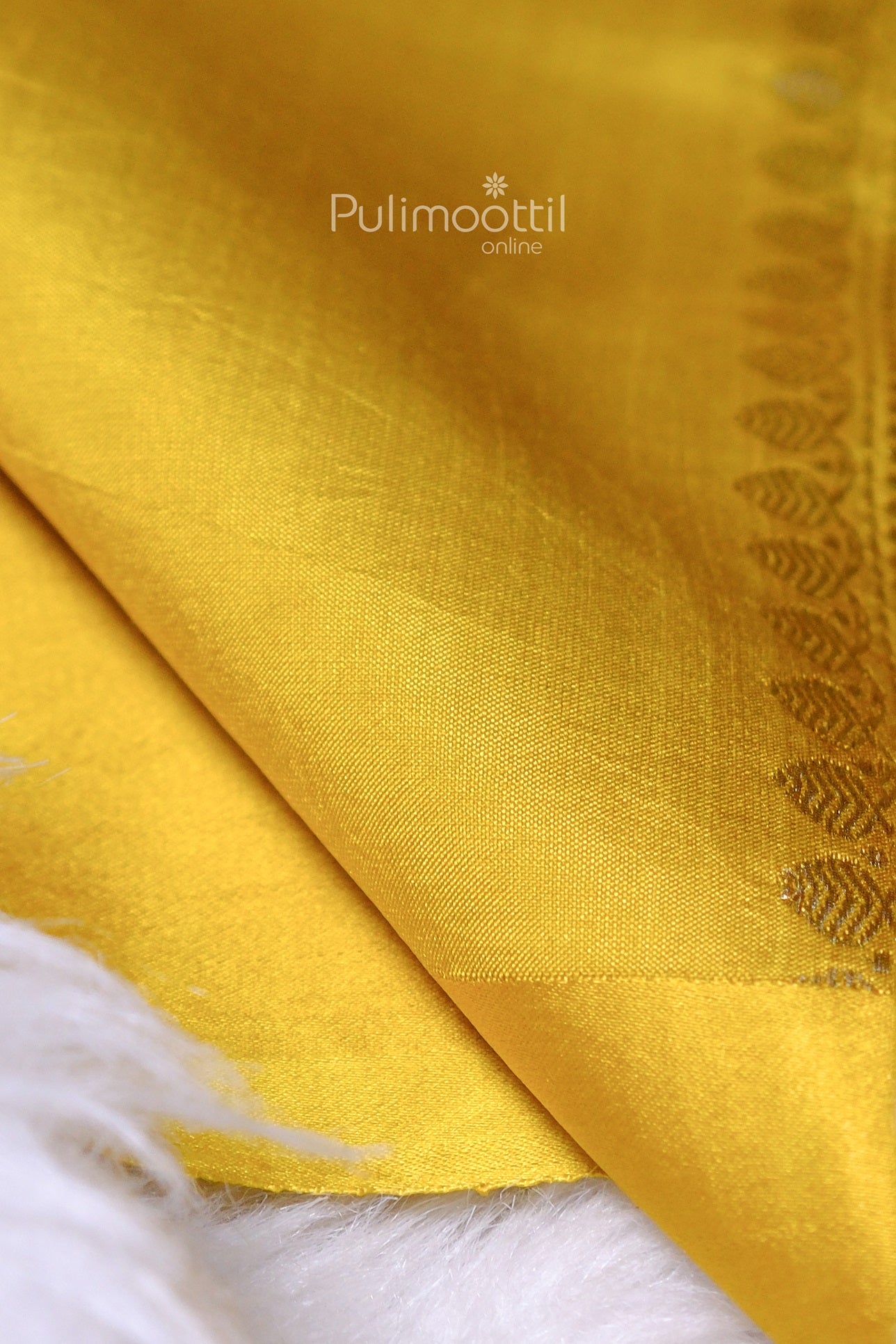 Kerala silk saree border close-up with subtle golden weave detail on yellow base fabric.