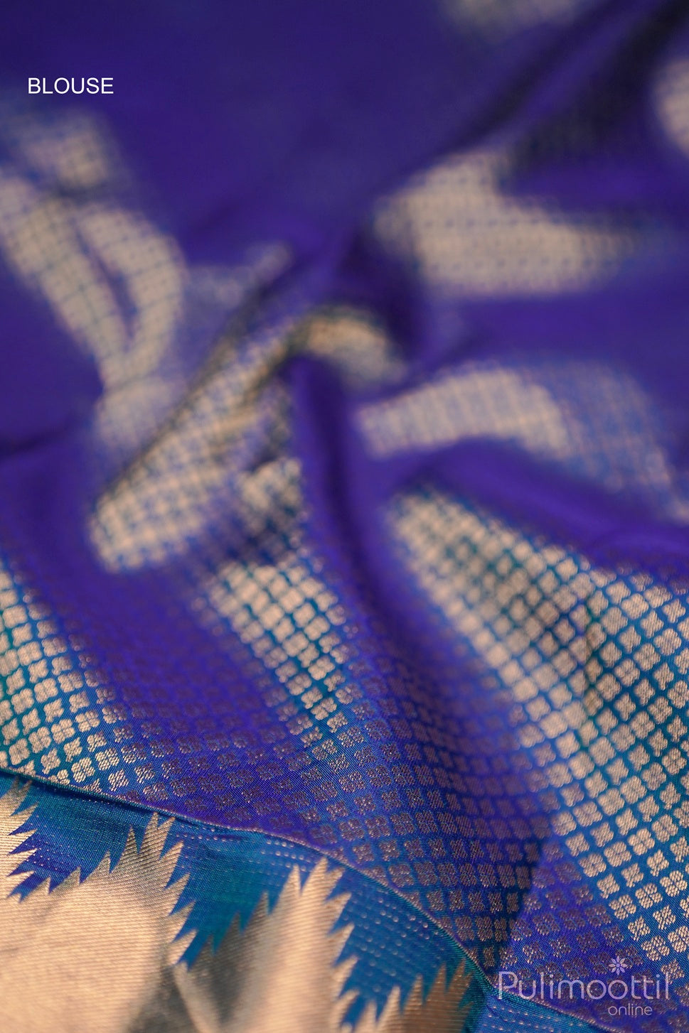 Close-up of peacock blue Kanchipuram saree blouse fabric with golden zari work.