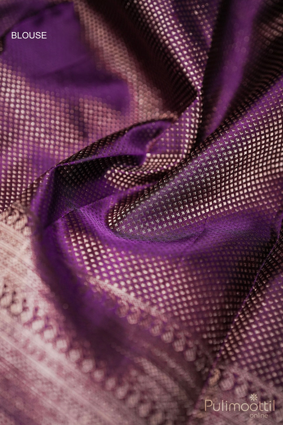 Close-up of purple Kanchipuram silk blouse fabric with textured golden zari detailing, showcasing a luxurious and smooth finish.