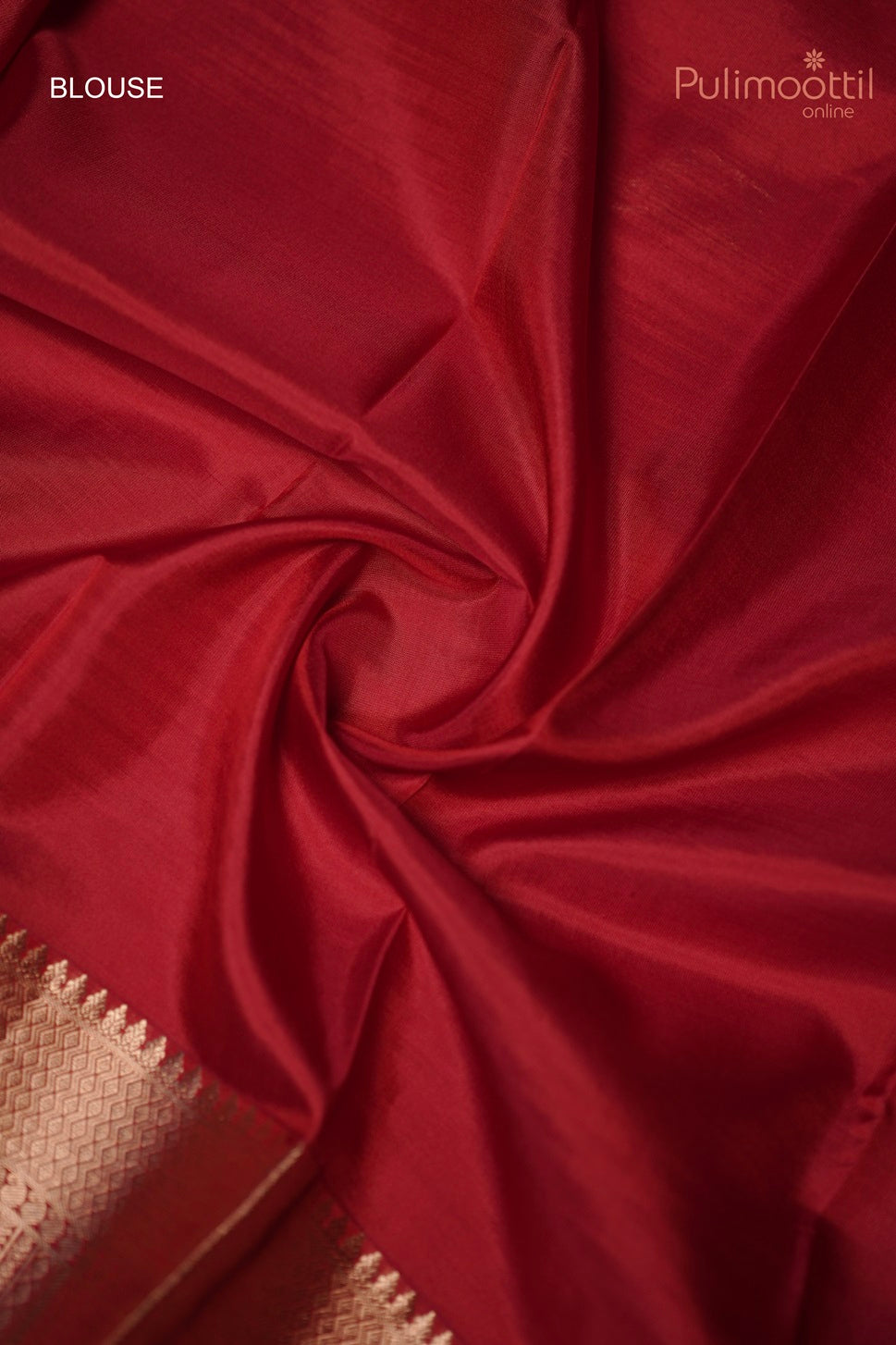 Close-up of chilli red blouse fabric with golden border detailing.