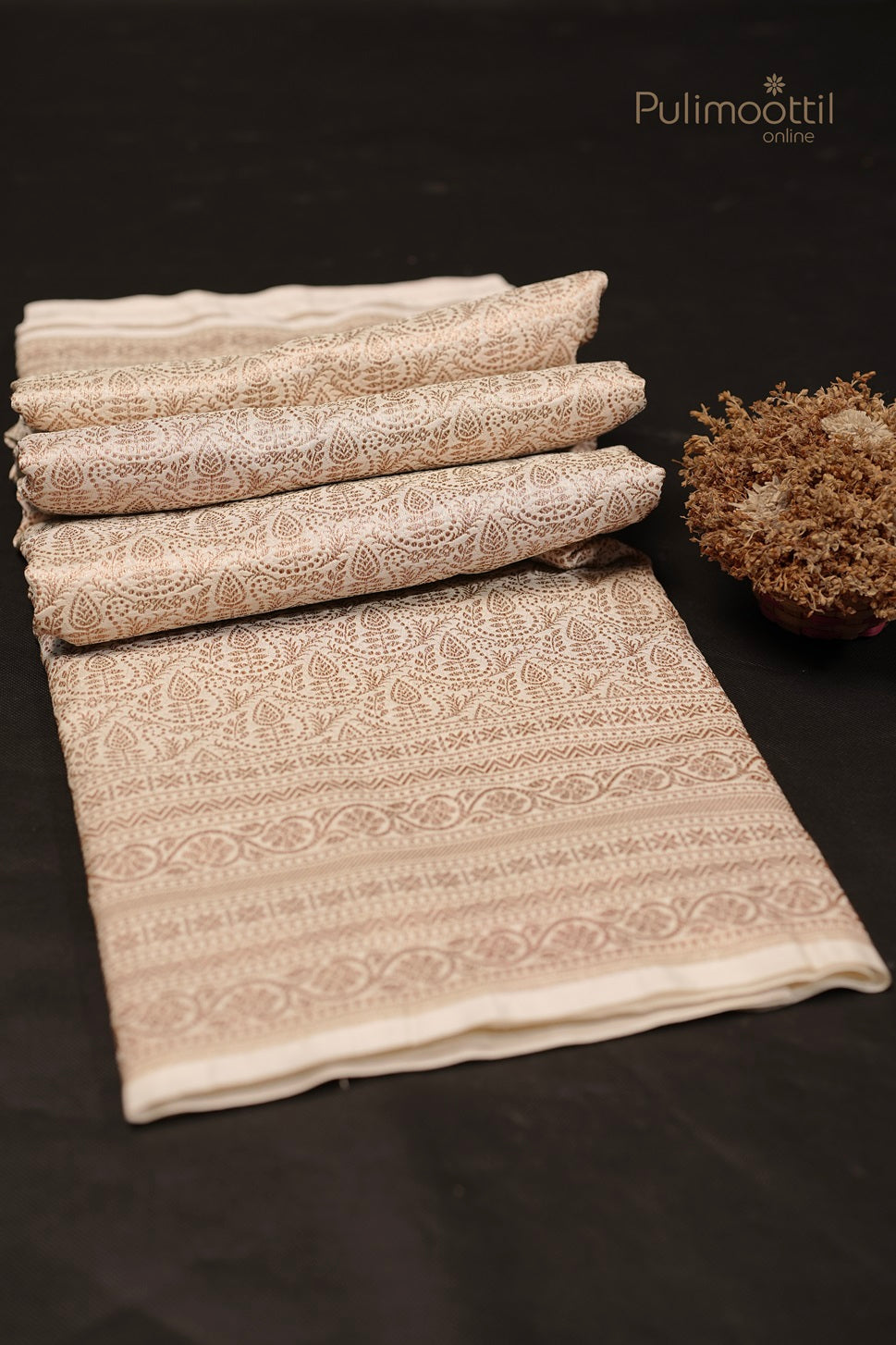 Folded white Kattan silk saree with intricate golden and thread floral design on body and border