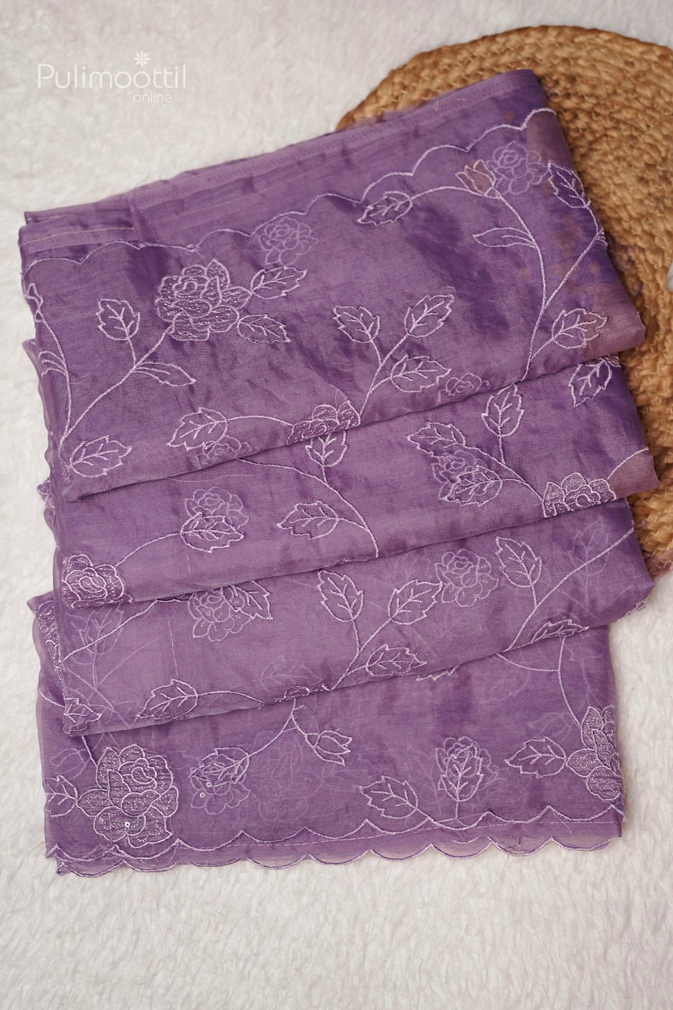 Close-up of lavender organza saree scallop border with intricate cut work and embroidery, showcasing elegant floral patterns for wedding and bridal sarees by Pulimoottil Silks Thrissur.