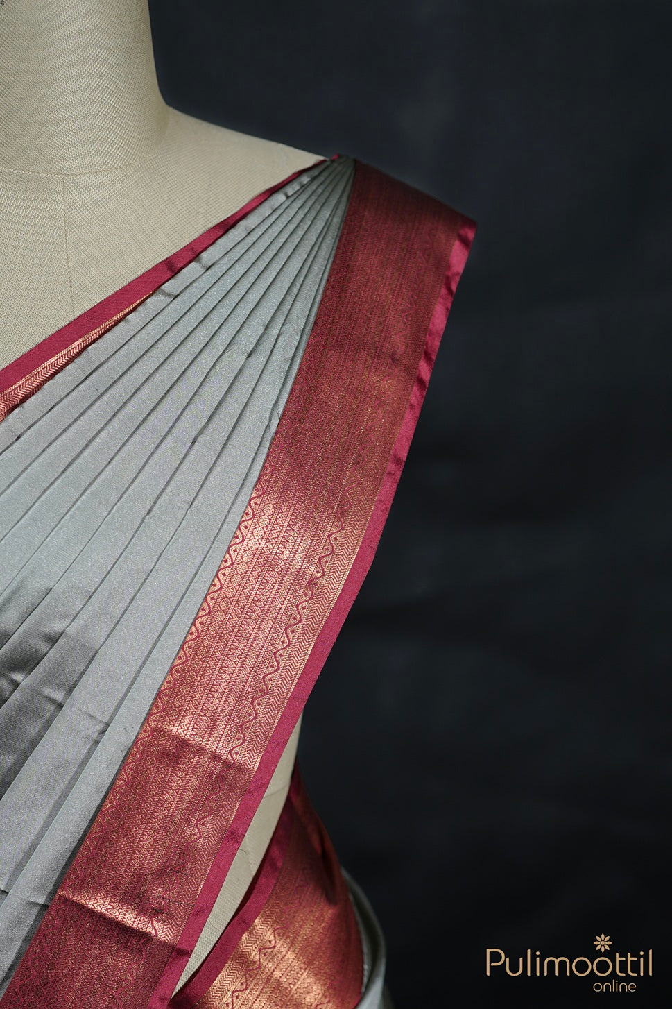 Gray saree with a maroon border on a mannequin against a black background, featuring the Pulimoottil brand.