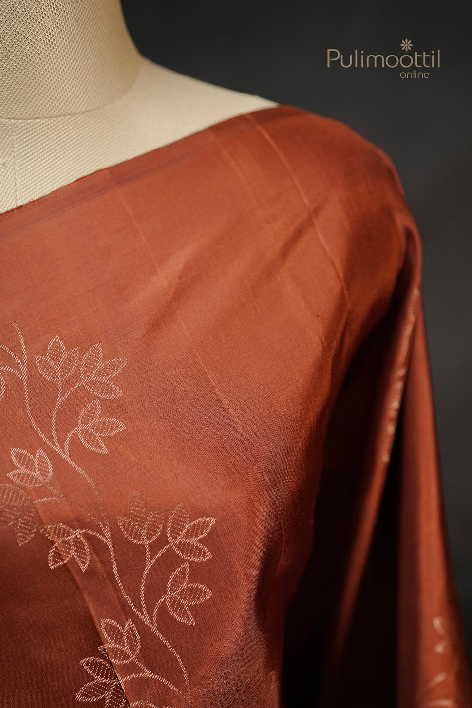 Mannequin shoulder detail of the Brick Shade Silk Saree, focusing on the woven copper and silver leaf motif on the body