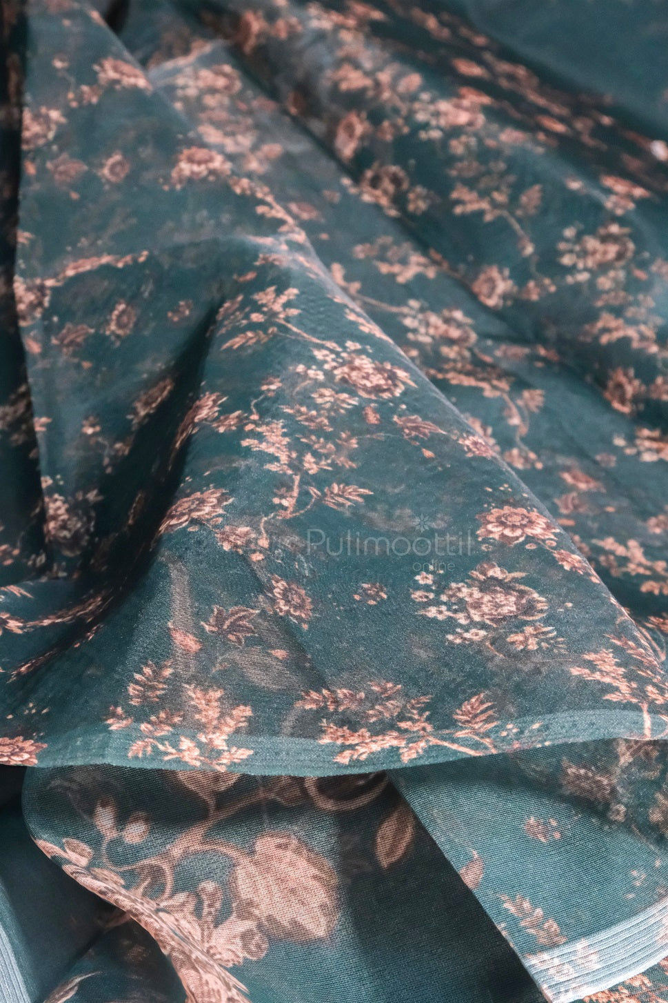 Matching dark green blouse piece with copper floral print, complementing the organza saree design.