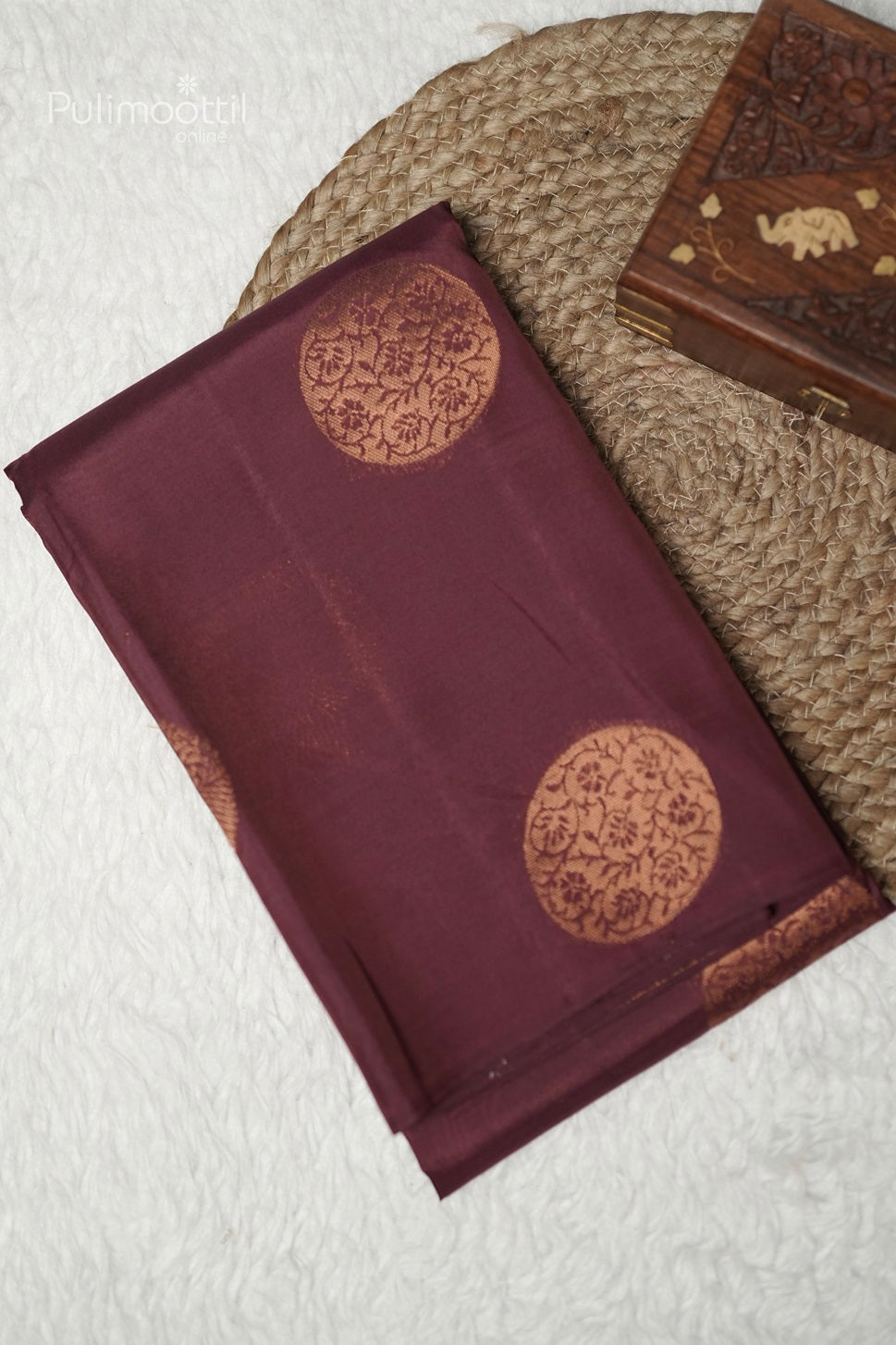 Folded terracotta Kanchipuram saree showing copper round buttas design