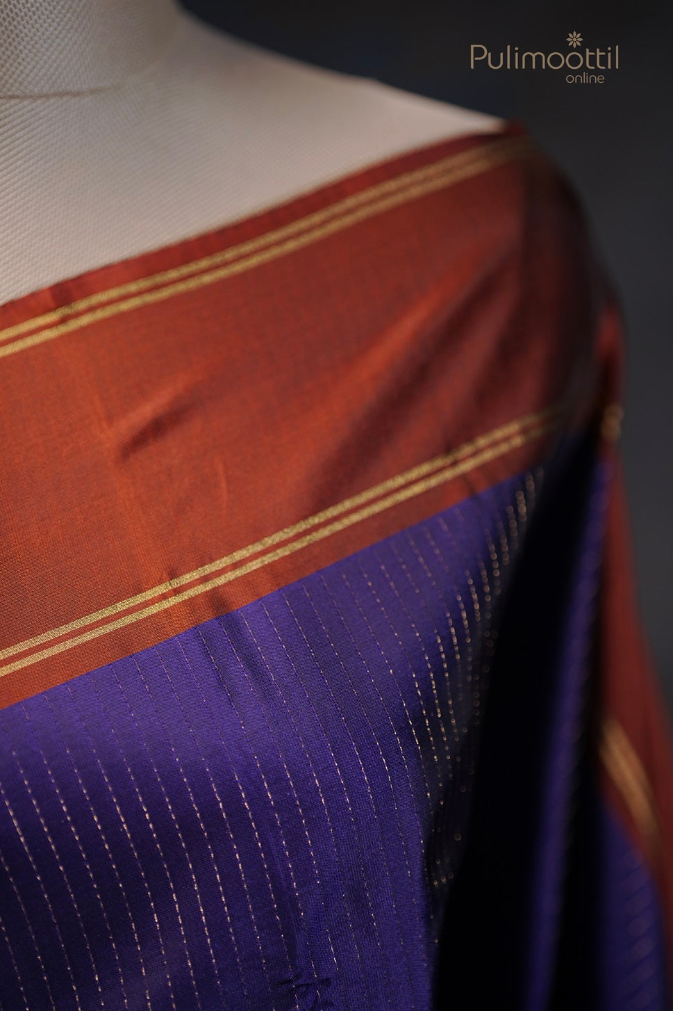 Close-up of floral buttas design on the rust-colored pallu of the saree with intricate golden zari work.