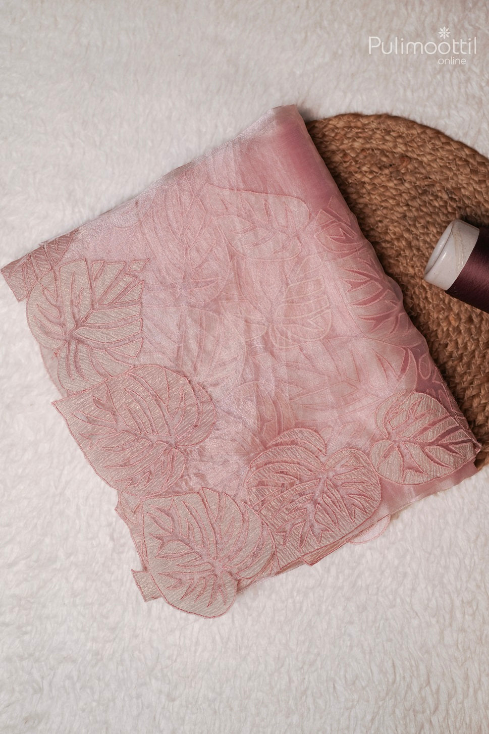 Light rose colour organza saree folded with plain body and one side applique work border, elegant wedding and bridal saree from Thrissur Pulimoottil Silks.