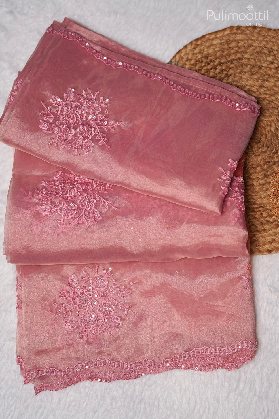Detailed close-up of thread and sequins embroidery on light deep pink organza saree with scallop border, showcasing fine craftsmanship for wedding and bridal sarees by Pulimoottil Silks.