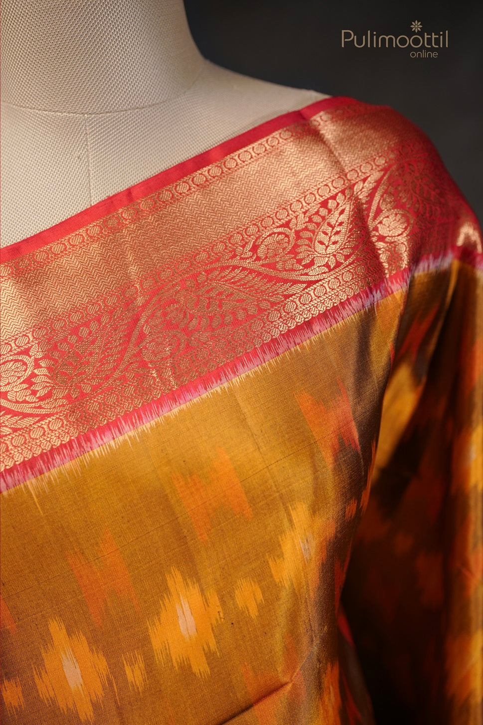 Golden yellow saree with Ikat print, featuring a rich red and gold zari border with intricate floral patterns.