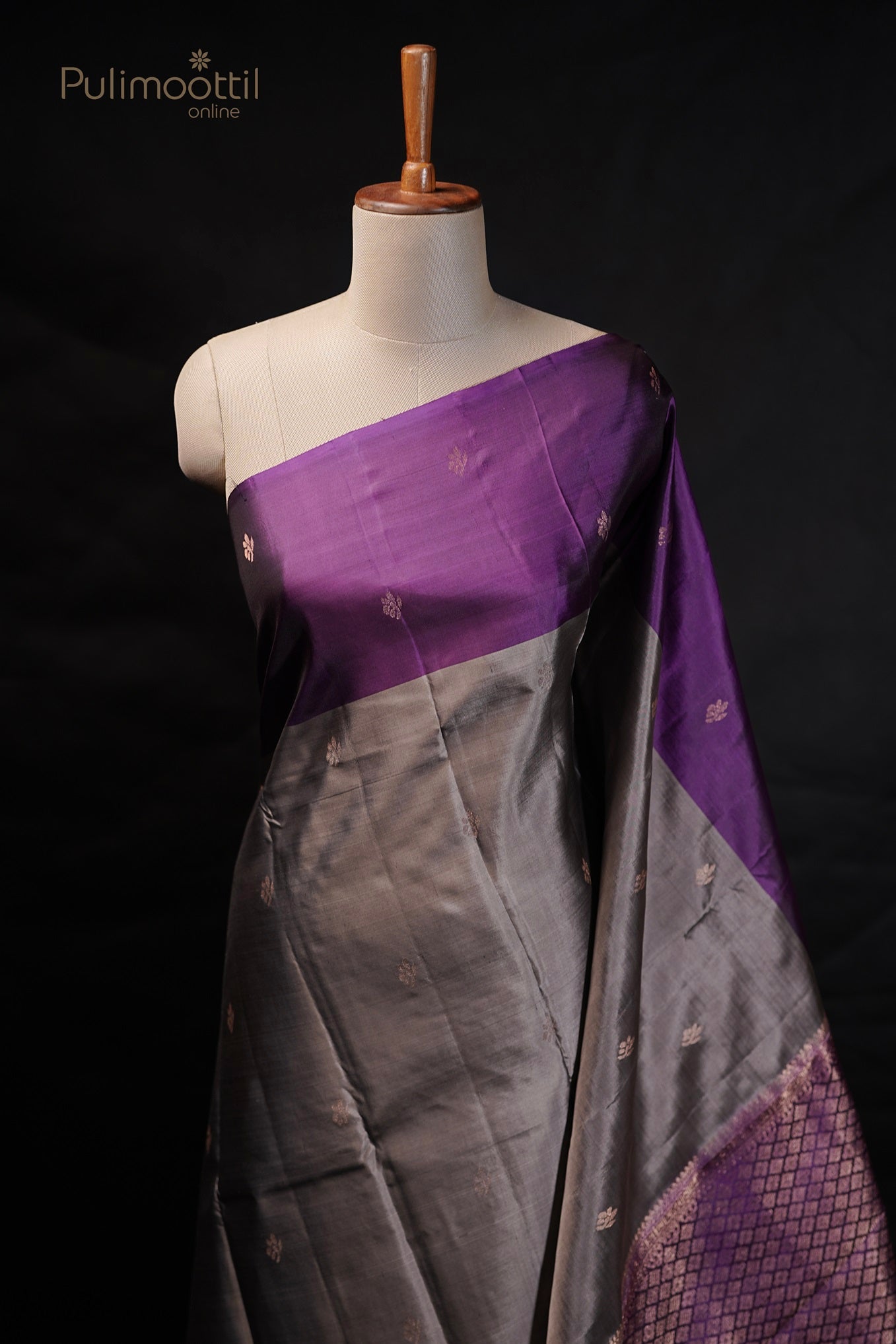 Grey Kanchipuram soft silk saree with golden buttas and purple contrast border, draped on a mannequin.