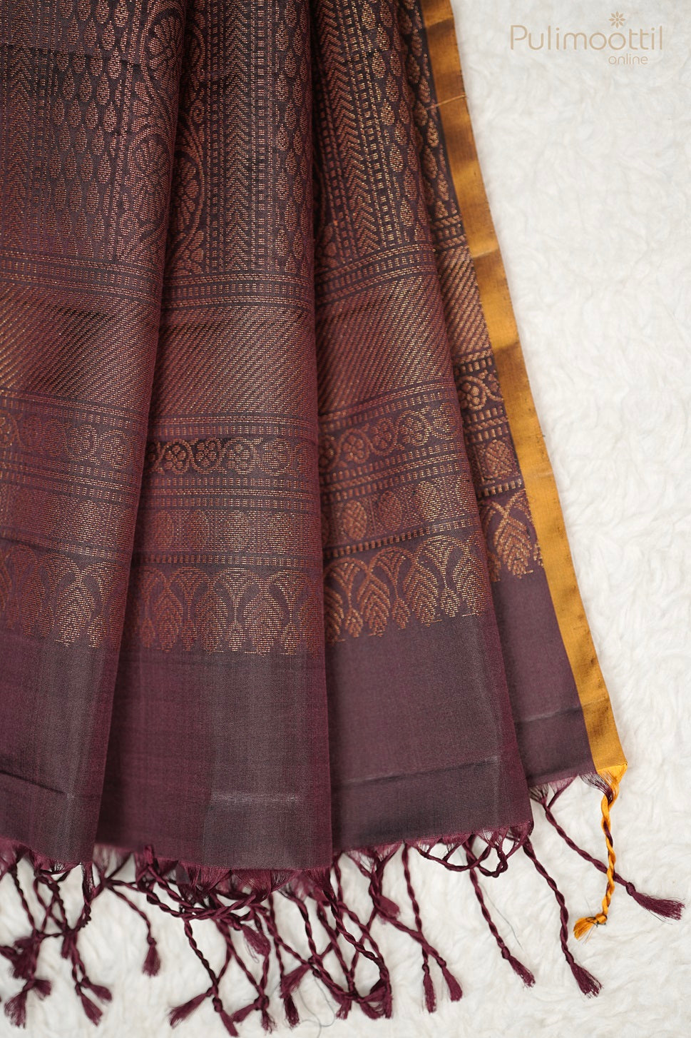 Detailed image of the Dark Maroon Saree's designer Pallu, showcasing the rich, detailed gold leaf and stripe weaving with matching tassels