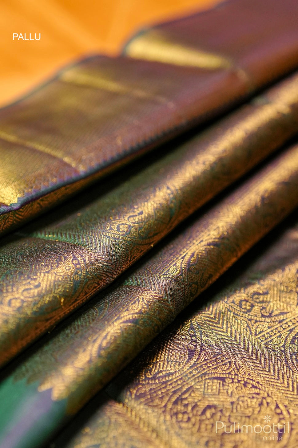 Close-up of a luxurious Kanchipuram silk saree pallu featuring intricate golden zari work with traditional patterns, showcasing a rich, elegant texture.