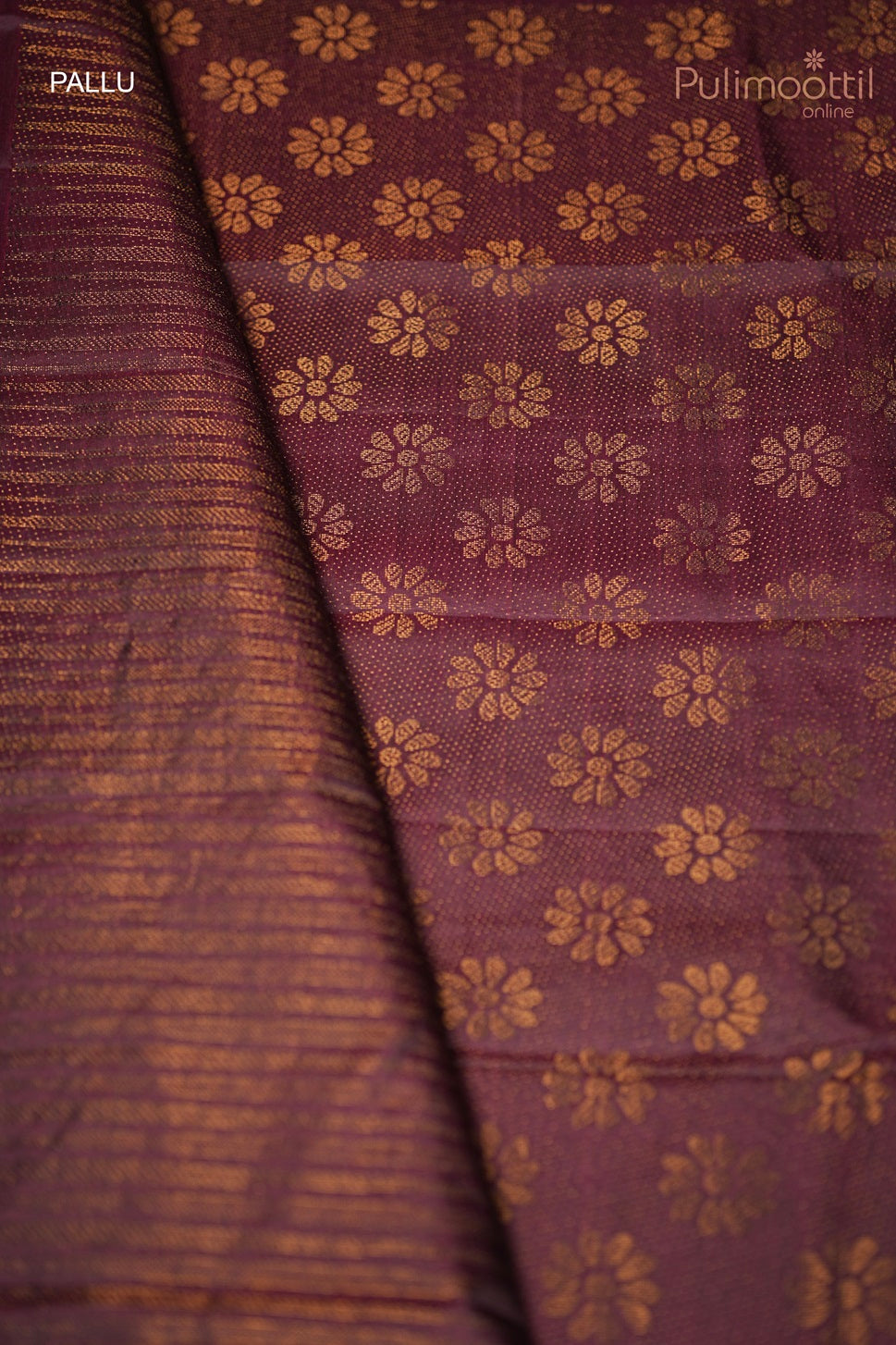 Close-up of the designer pallu of the dark purple Kanchipuram saree, featuring golden floral motifs and striped detailing.
