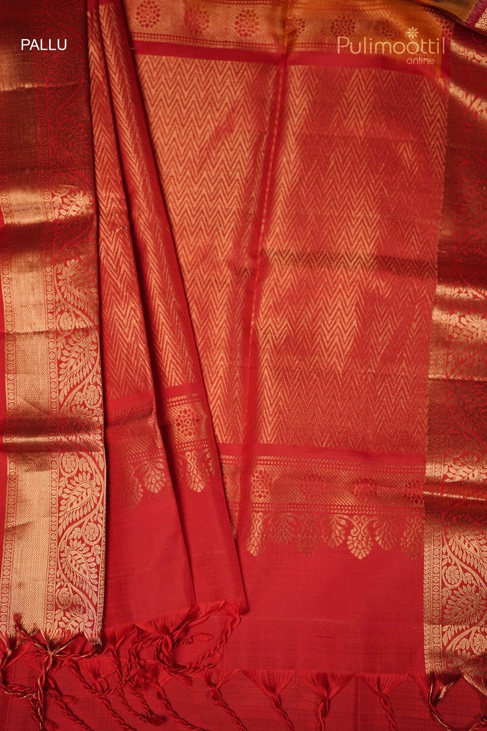 Red saree pallu with golden zari border featuring intricate floral and zig-zag patterns, with tassels at the edge.
