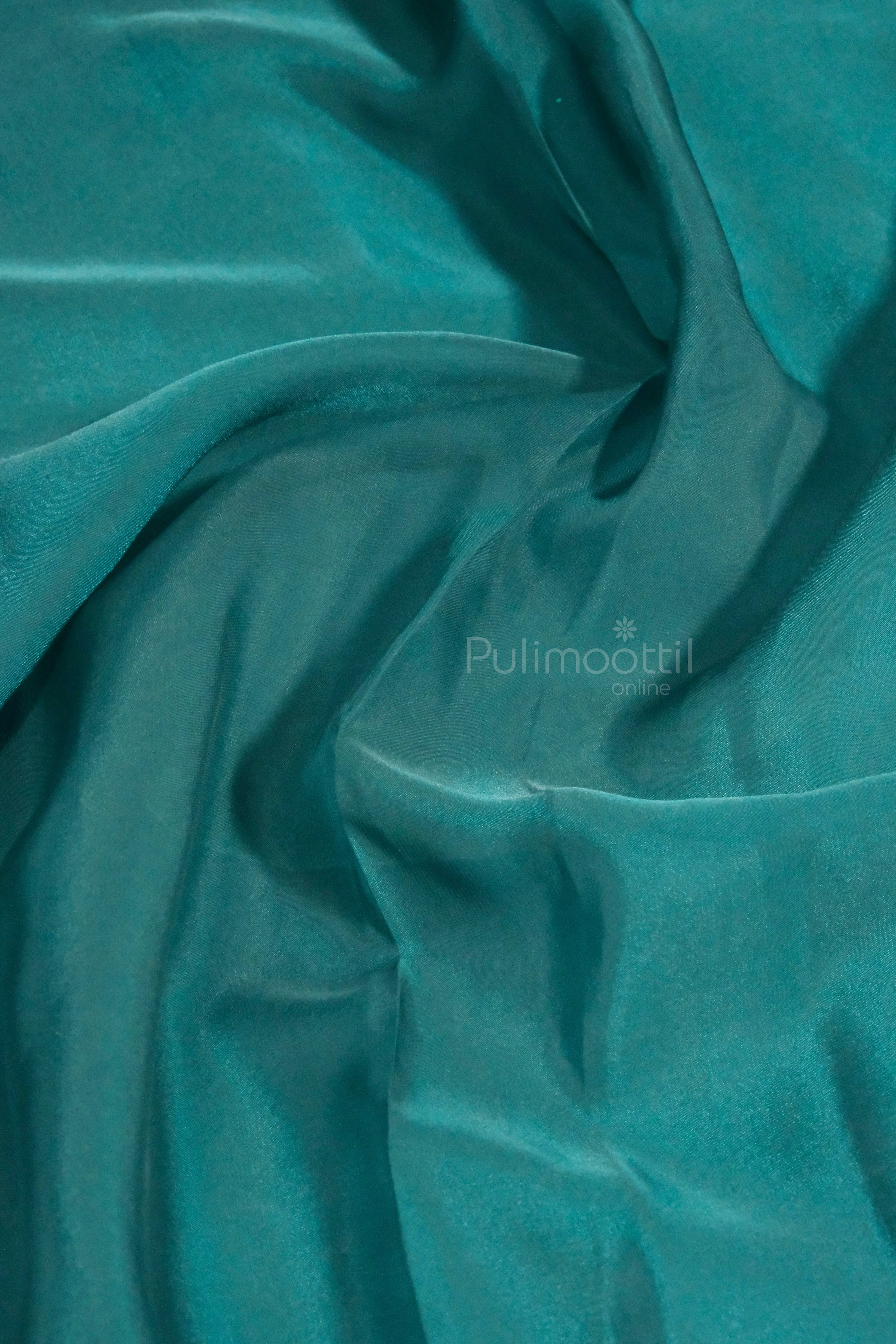 Plain unstitched peacock blue blouse fabric included with the saree, matching the base color for a coordinated and elegant ensemble.