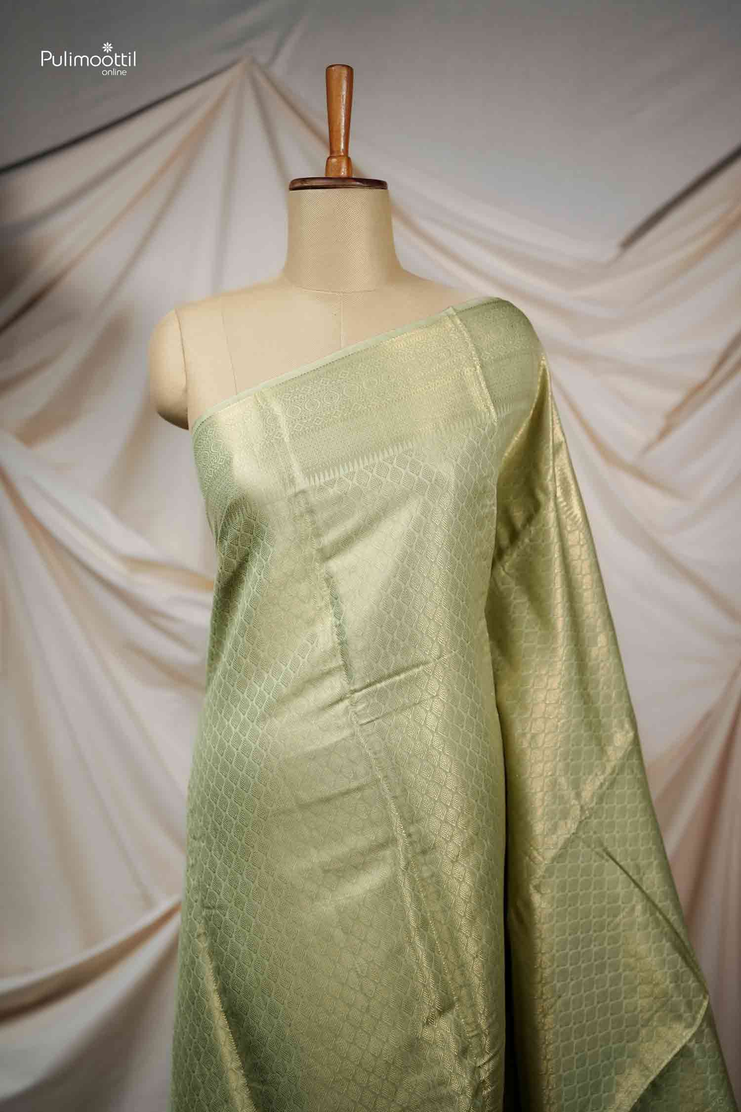 Full shot of the elegant Pistachio Green Kanchipuram Silk Saree draped on a mannequin, showcasing the all-over self-woven diamond motifs