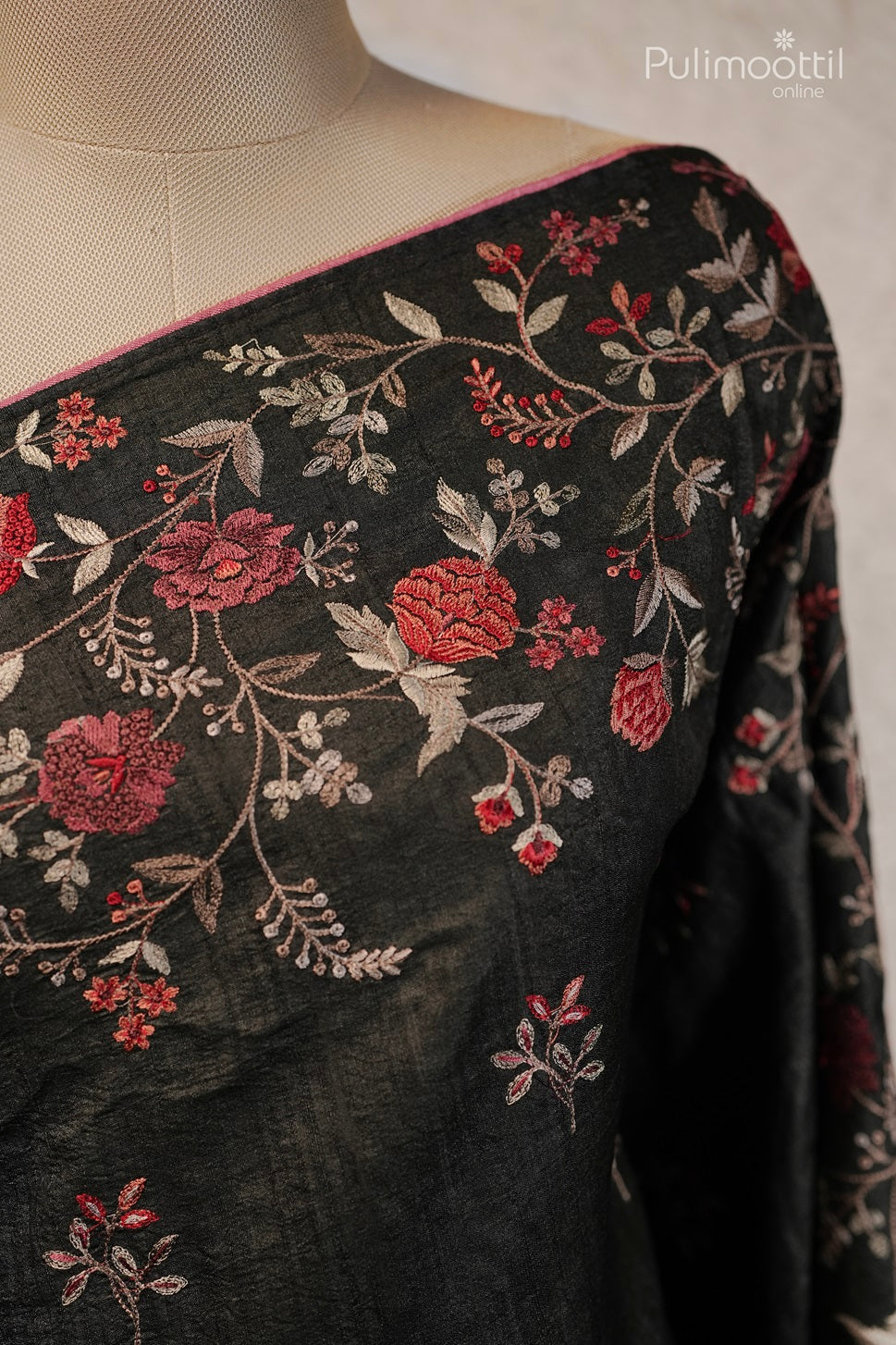 Black blouse fabric with red and white floral embroidery along the neckline, featuring intricate vines and leaves with a pink piping detail.