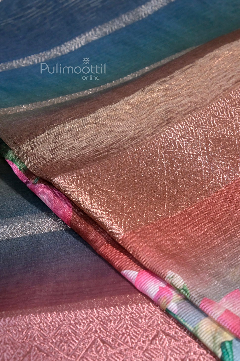 Folded rainbow-colored crushed organza tissue saree showing shimmer texture and multi-toned sheen.