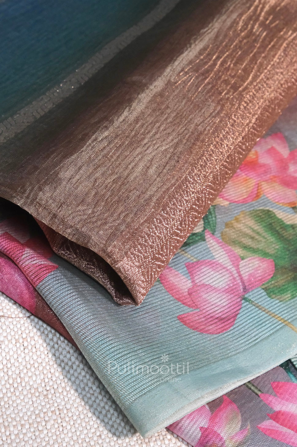 Close-up of saree border with crushed metallic bronze and teal tones, overlapping floral-printed organza.