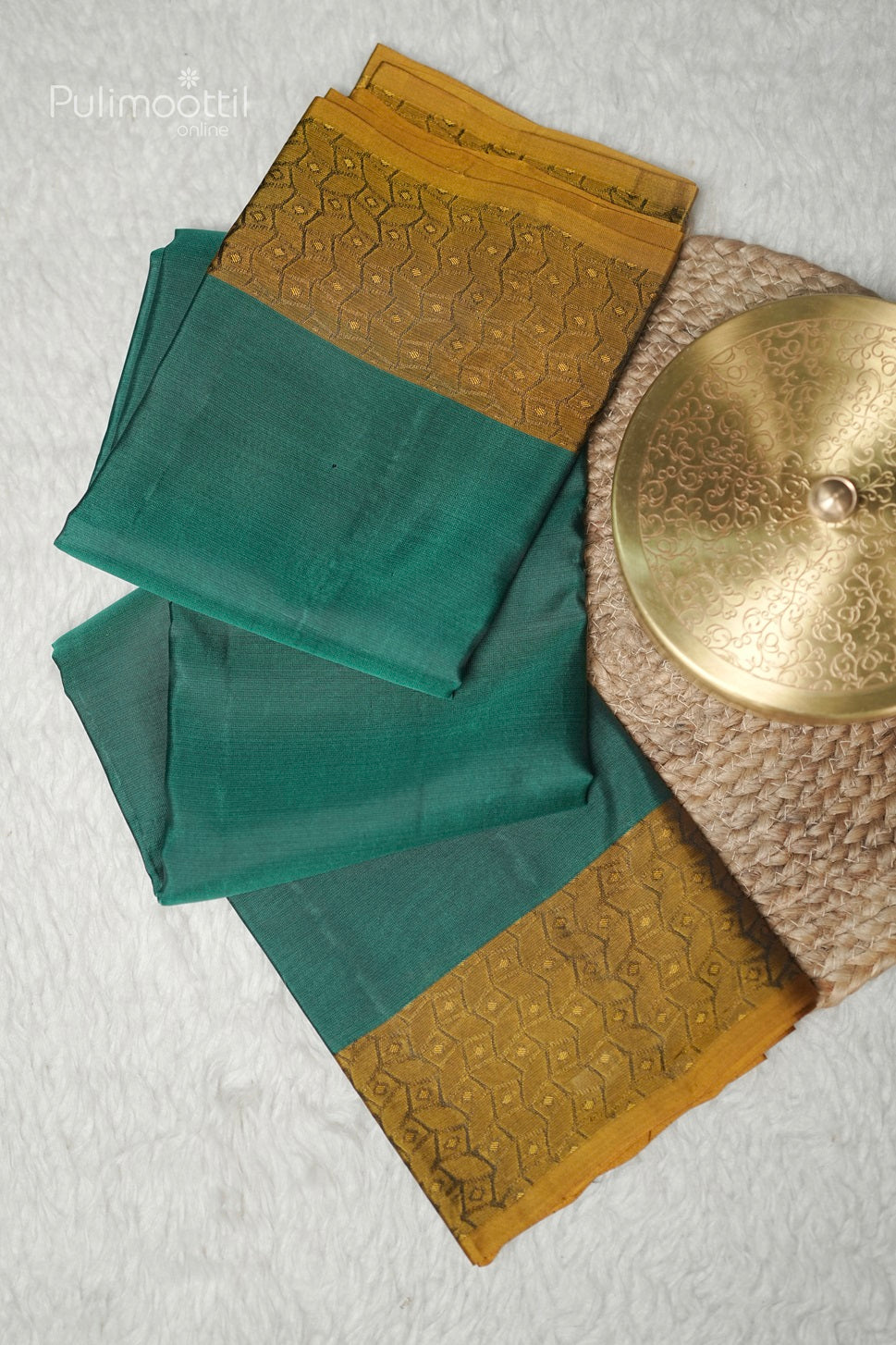 Close-up of golden self print border on peacock green Kanchipuram saree