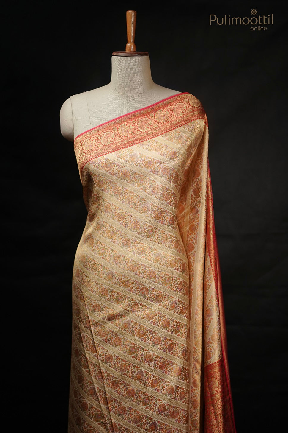Pastel multishaded organza fancy saree draped on mannequin with broad multicolored stripes, golden buttas, and vertical striped border, perfect for wedding and bridal sarees from Pulimoottil Silks.