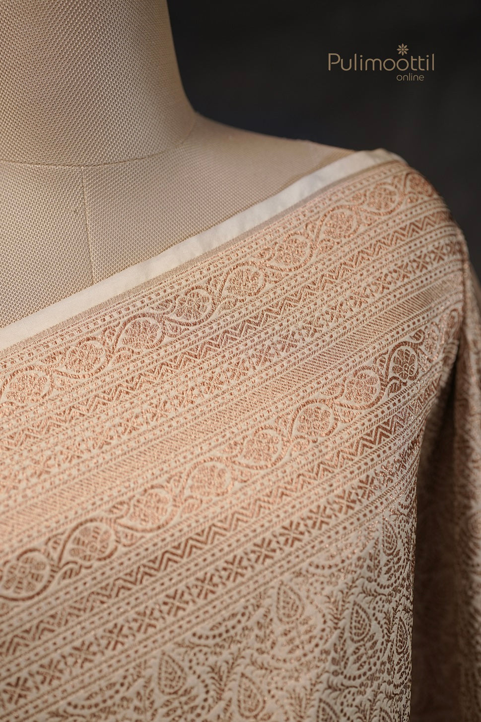 Close-up of white Kattan silk saree fabric showing detailed golden and thread woven border design