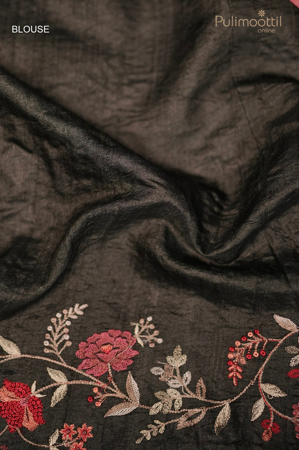 Black blouse fabric with red and white floral embroidery, featuring delicate vines and leaf patterns.