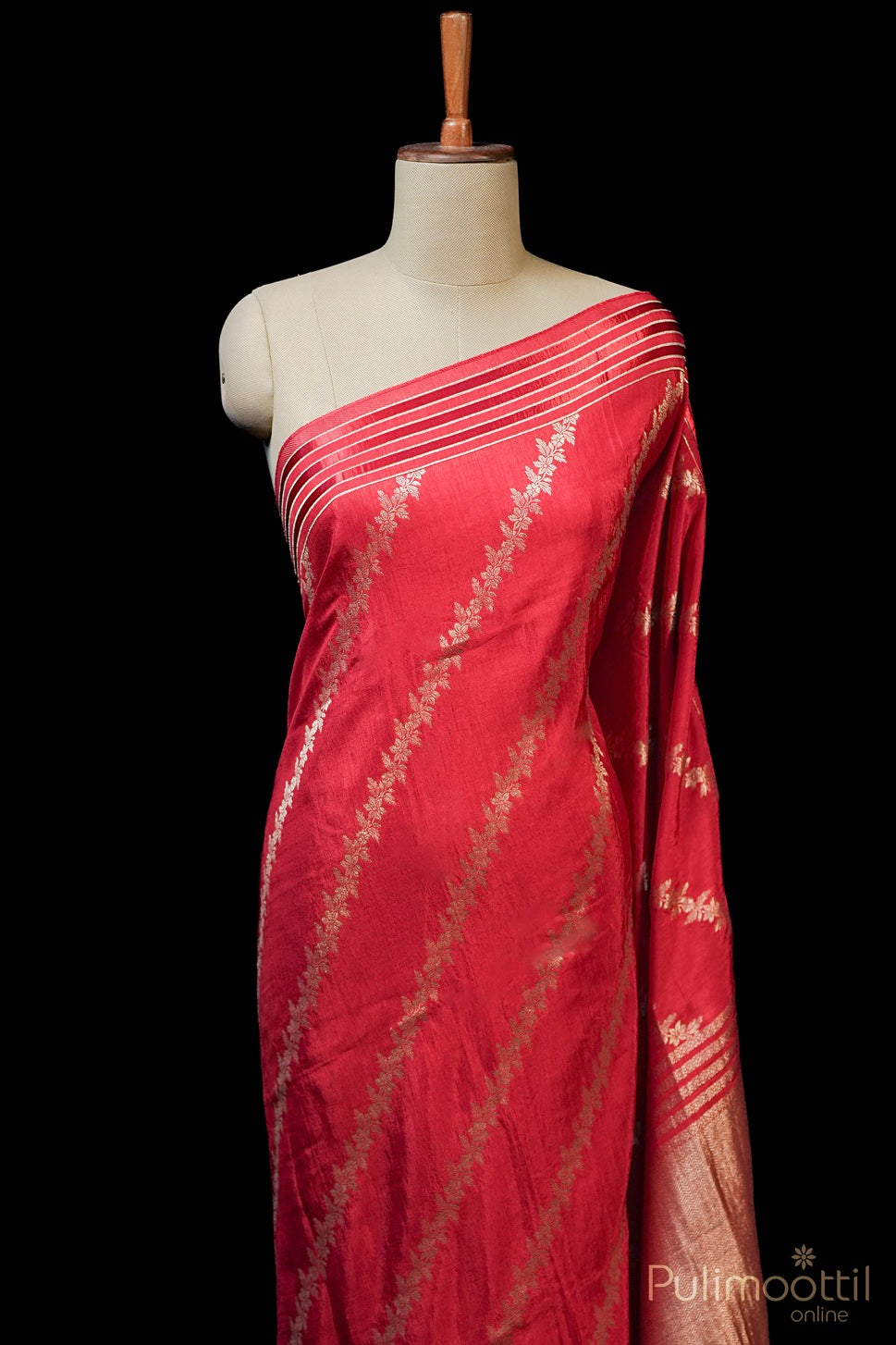 Red traditional Indian saree with gold floral patterns on mannequin, perfect for festive occasions