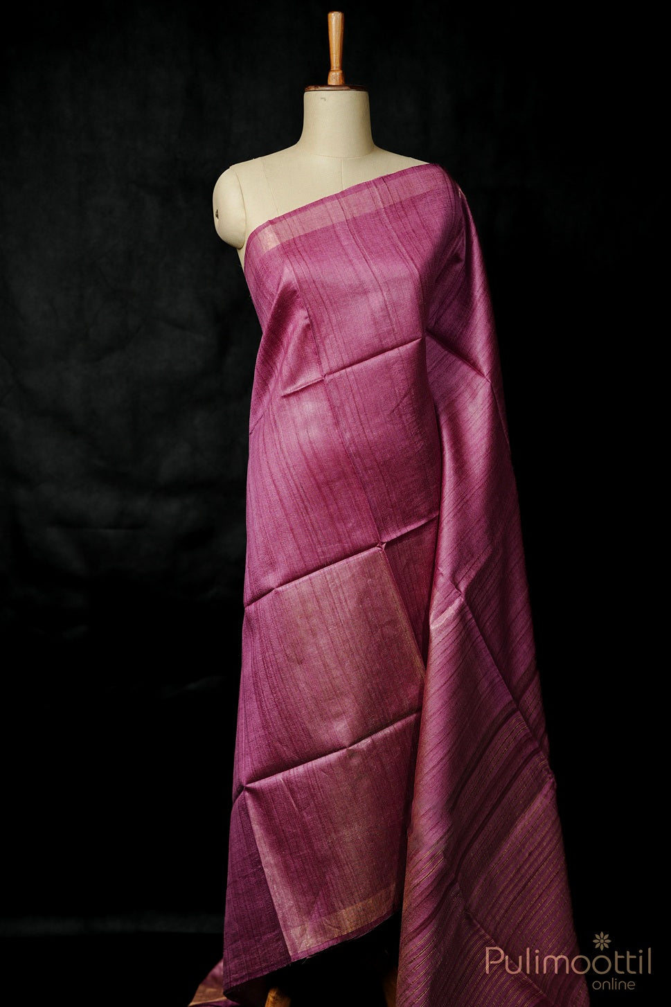 Mannequin wearing a draped purple fabric kanjipuram saree with a dark background