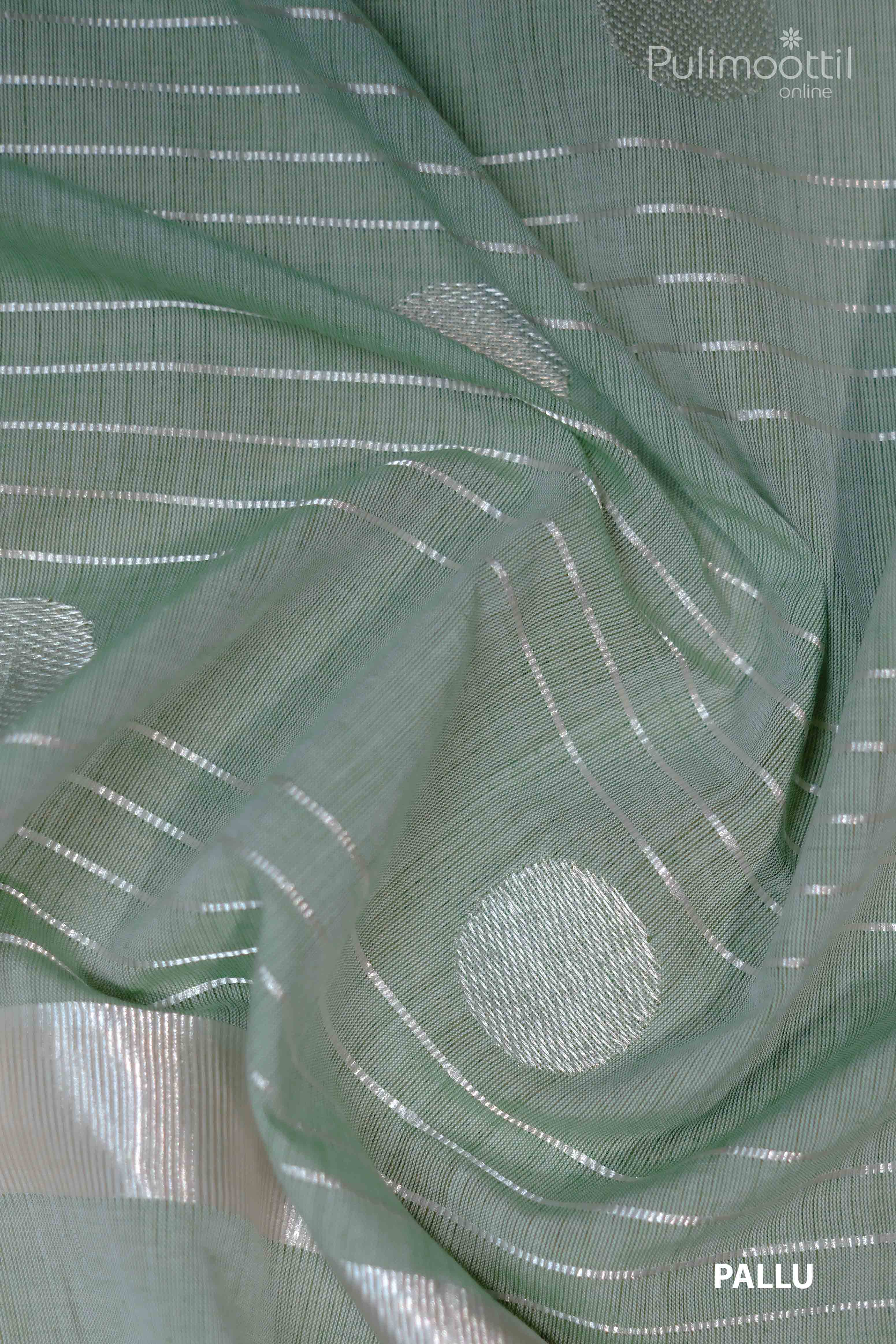 Close-up view of light pista green saree pallu featuring silver zari buttas and horizontal zari stripes on fine handloom cotton fabric.