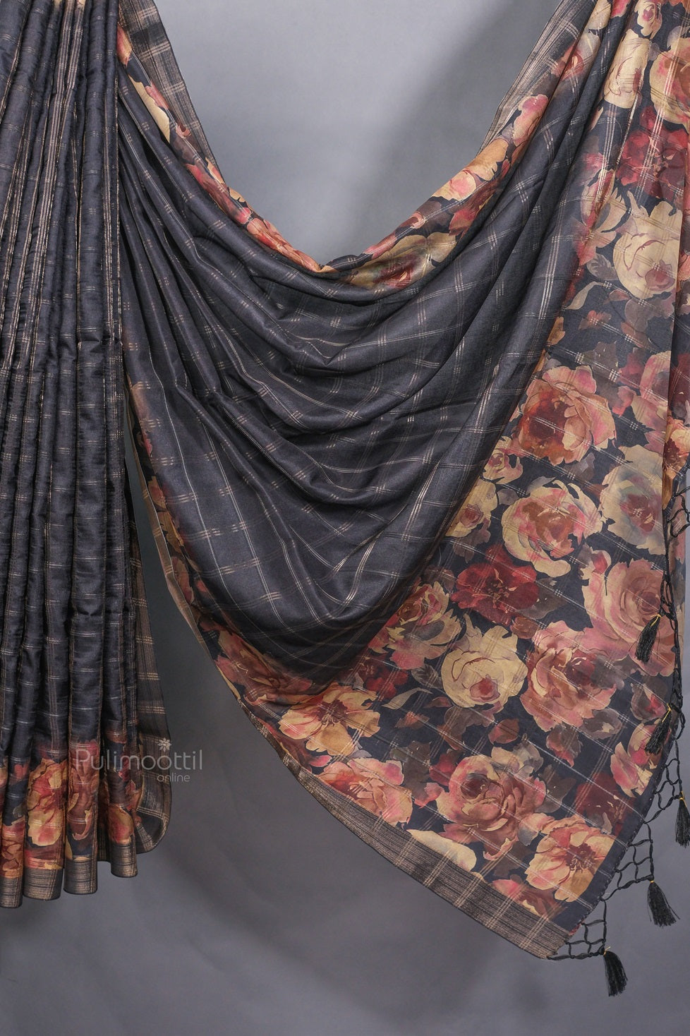 Close-up of the pallu and border of a black semi tussar silk saree featuring intricate woven detailing and subtle sheen.