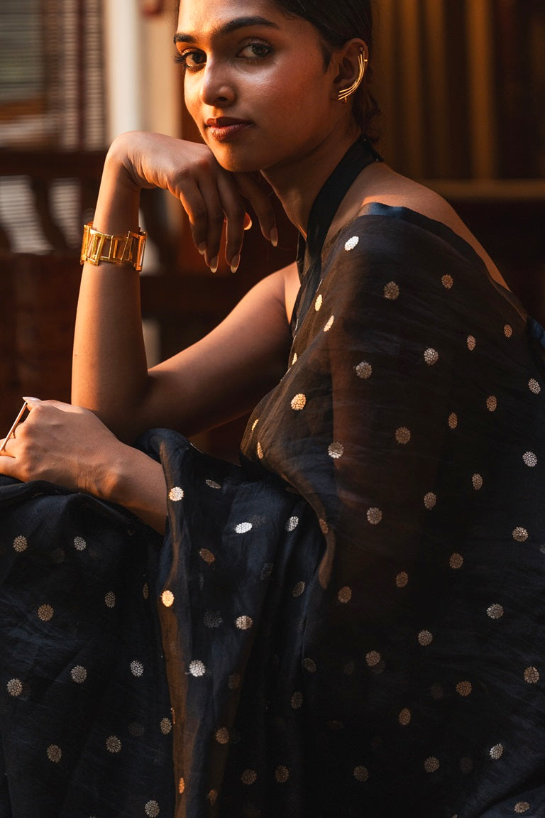 Black organza saree with golden silver zari butta patterns - close-up showing fabric texture and drape details