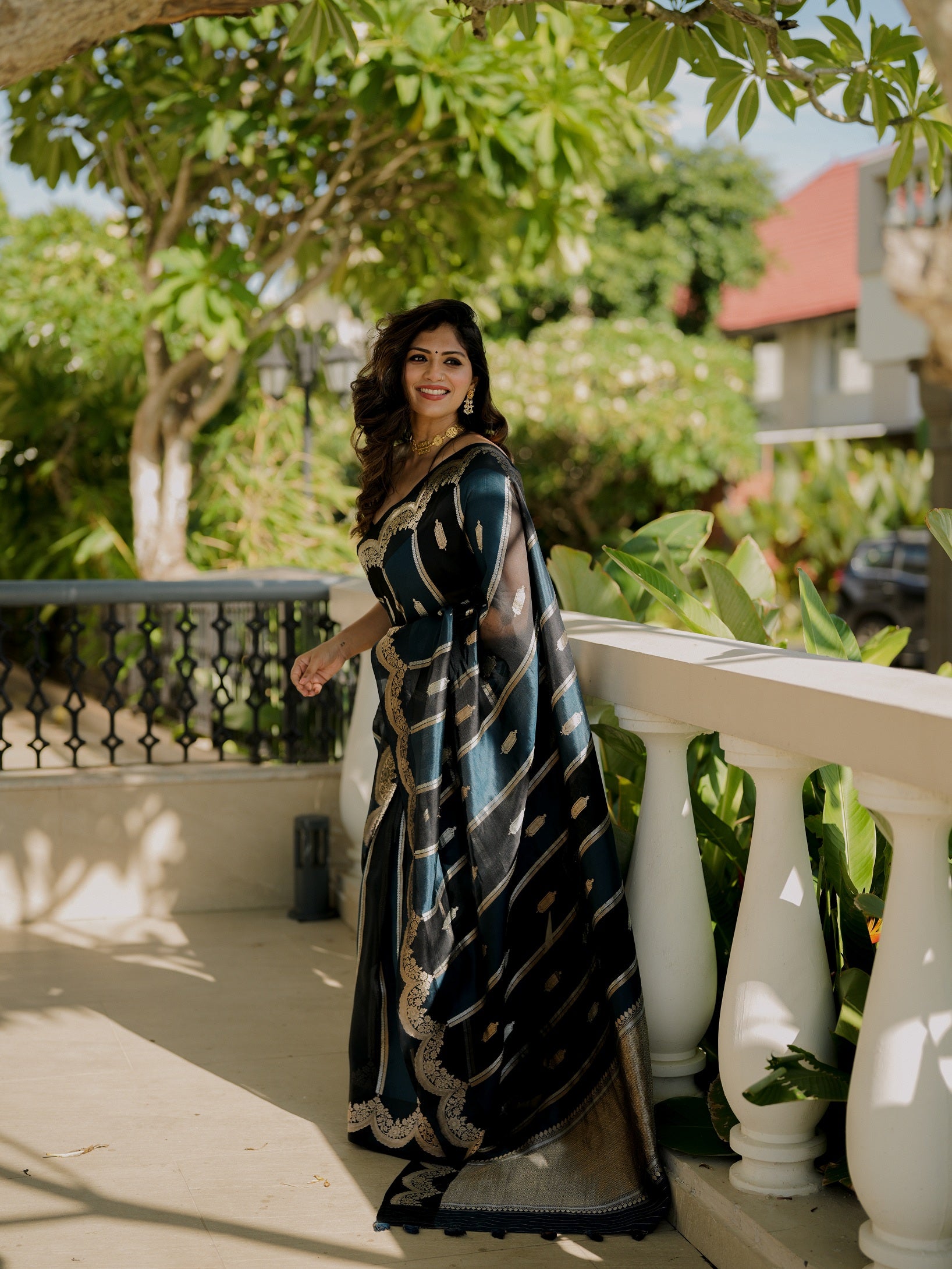 Model wearing a Pure Mango Silk Banarasi saree in blue and black with antique zari border, showcasing full-length front view.