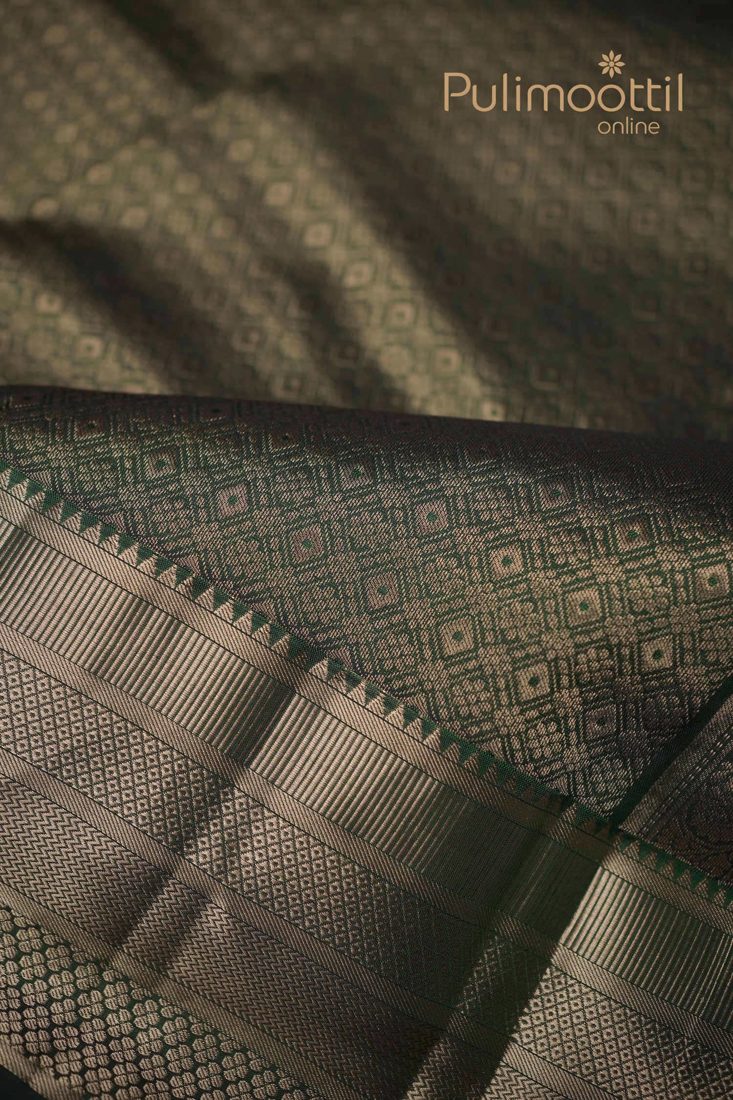 alt="Bottle‑green Kanchipuram silk saree with golden zari stripes and delicate butta pattern"
