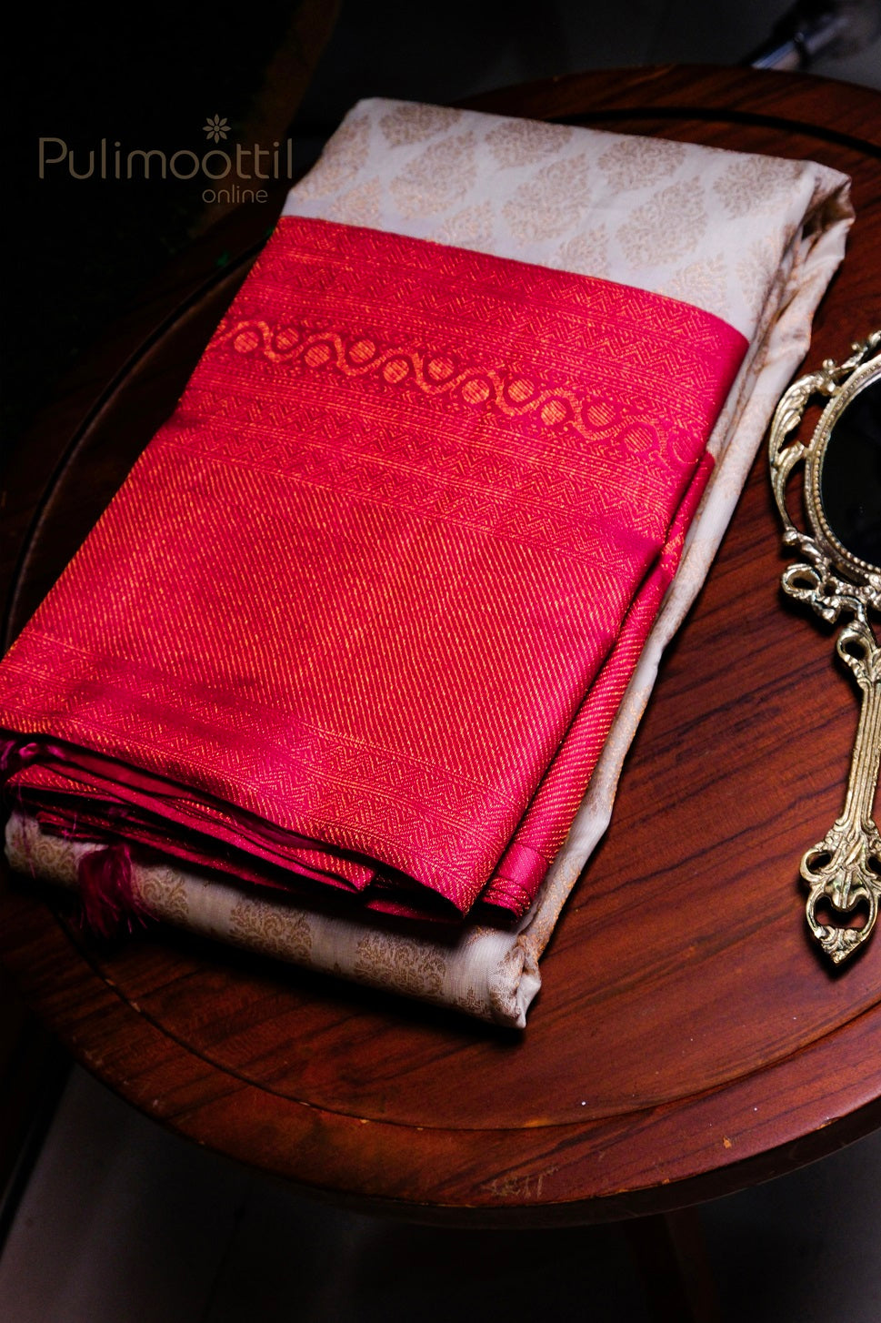 Ripe plum purple pure Kanchipuram bridal silk saree folded, showcasing rich gold zari square motifs and temple border