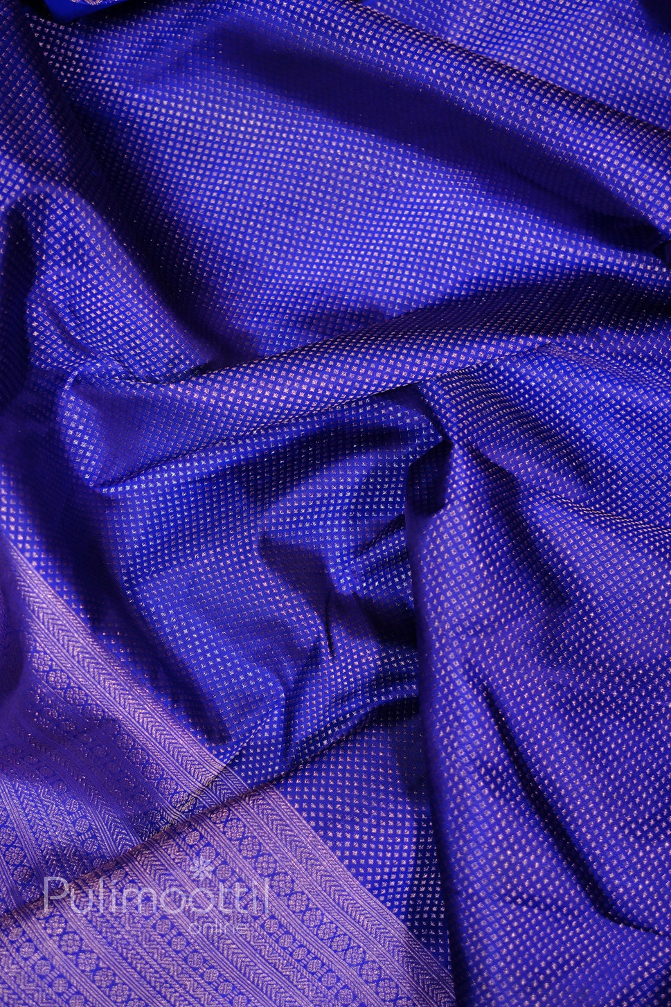 Crinkled royal blue Kanchipuram silk saree with dense gold-zari micro-motif weave and subtle sheen.
