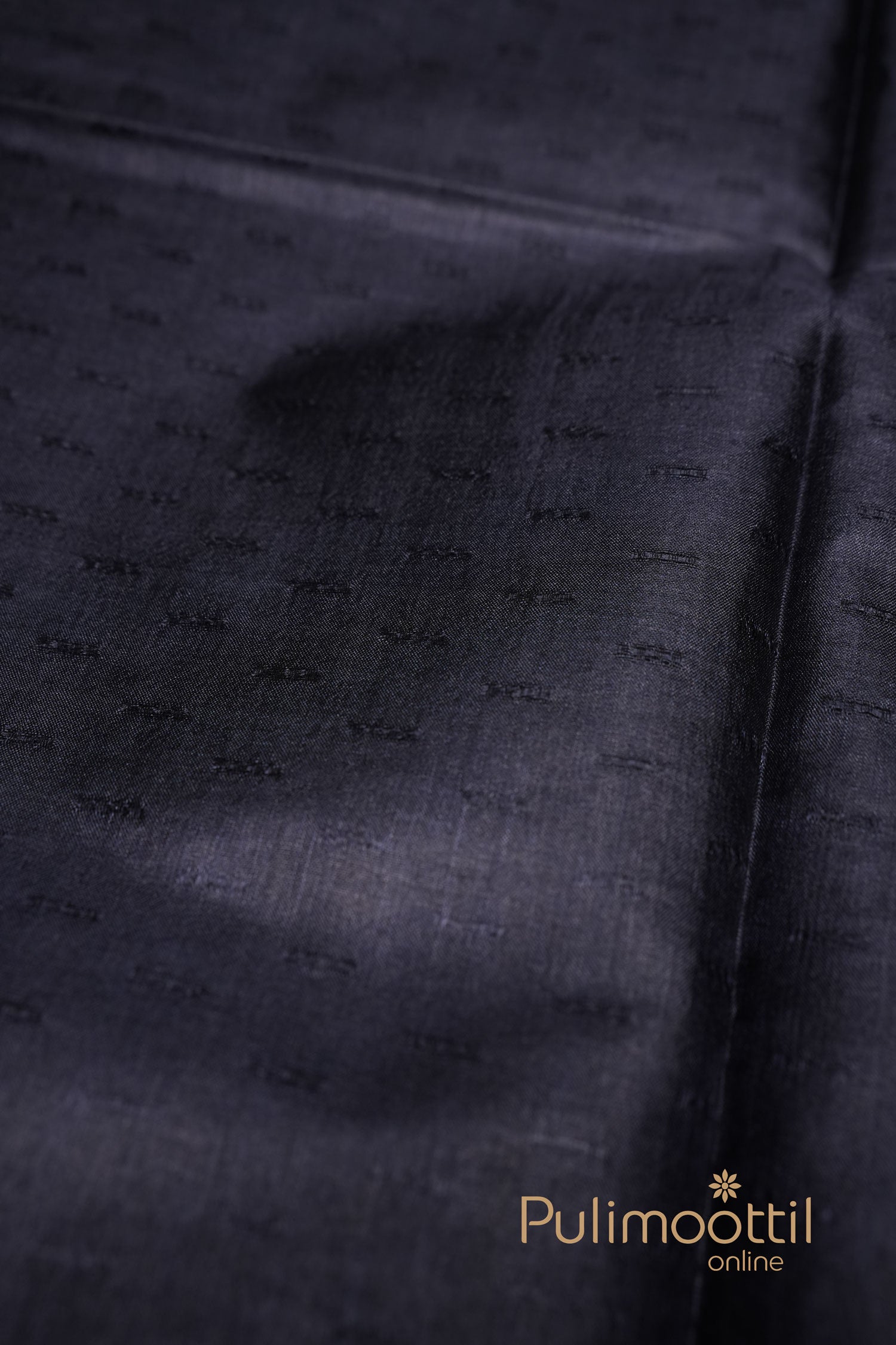 Charcoal black Tussar silk saree featuring an all-over subtle self-thread geometric pattern on the body with no visible border – Pulimoottil branding in the corner