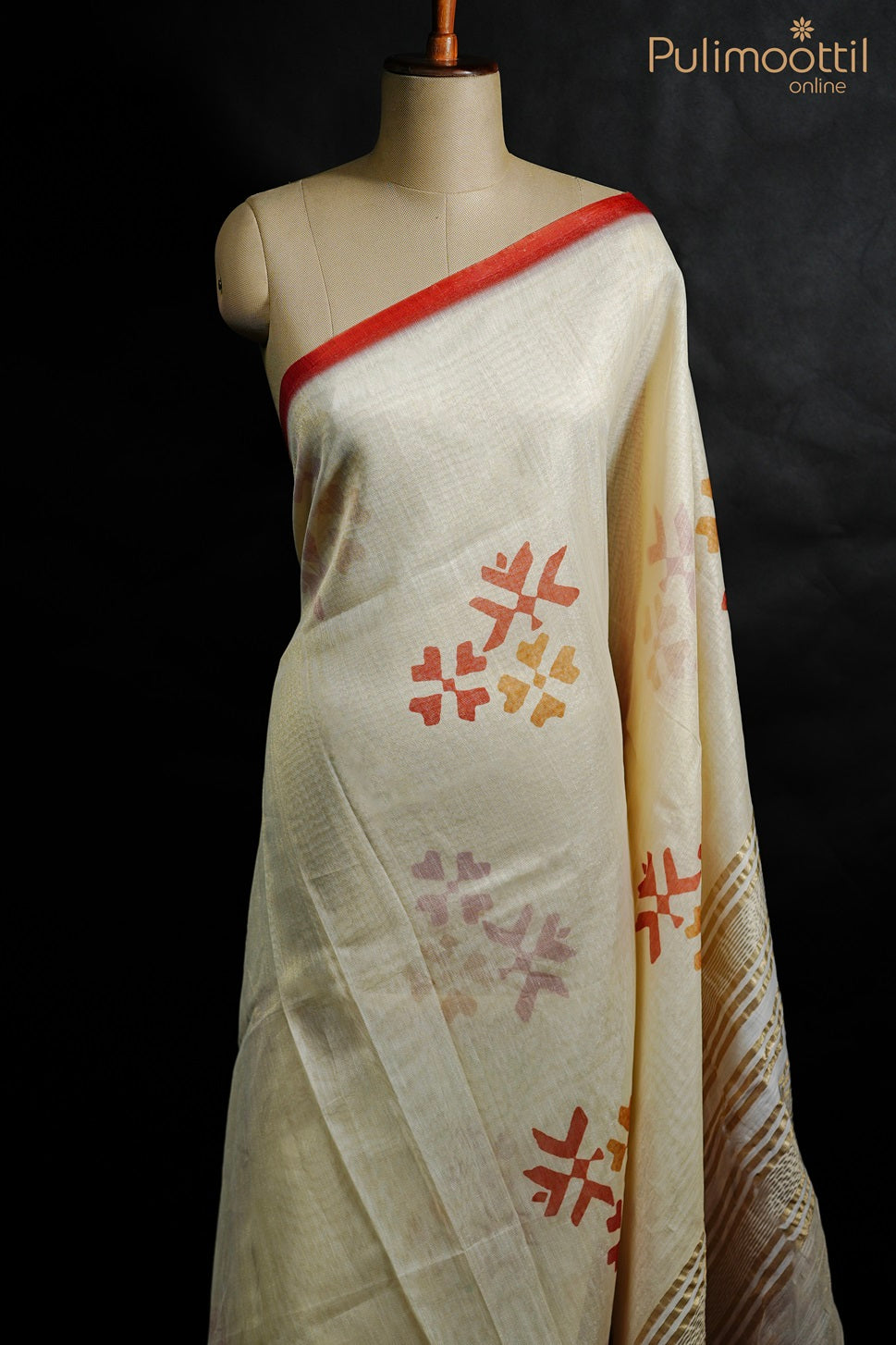 Cream color net cotta set saree with multicolor floral motifs on the body, red border, and golden striped pallu. Paired with a red blouse featuring golden floral motifs.