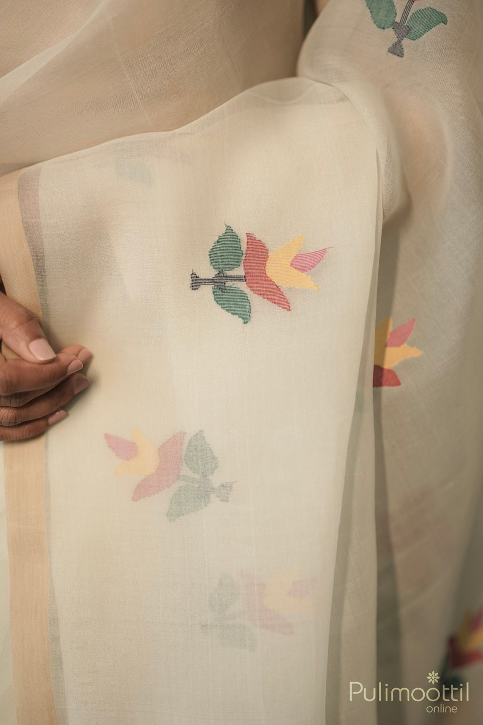 Close-up of floral Jamdhani motifs on cream organza saree fabric.