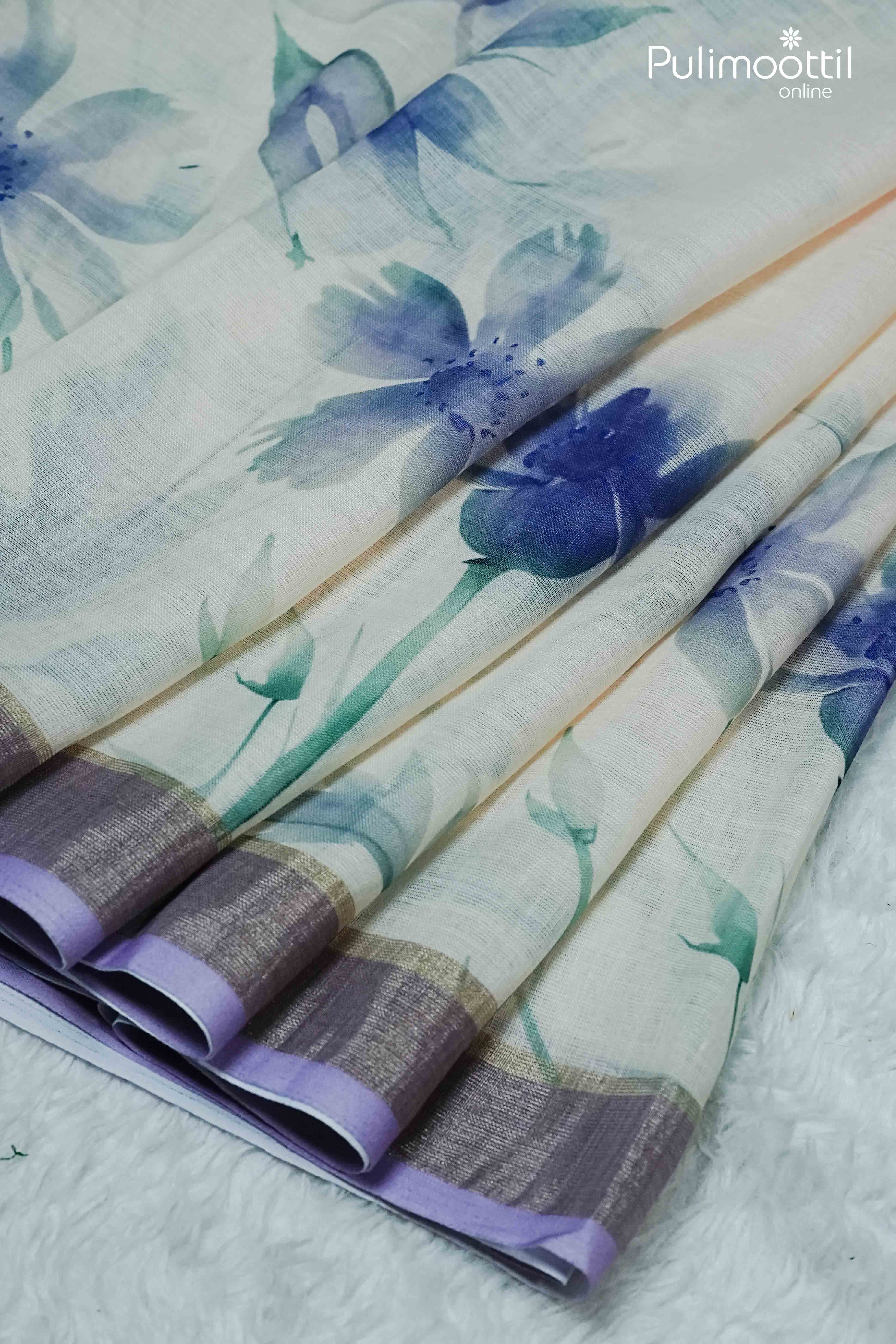 Cream semi linen saree with blue floral print and contrast lavender border, neatly pleated – Pulimoottil Online