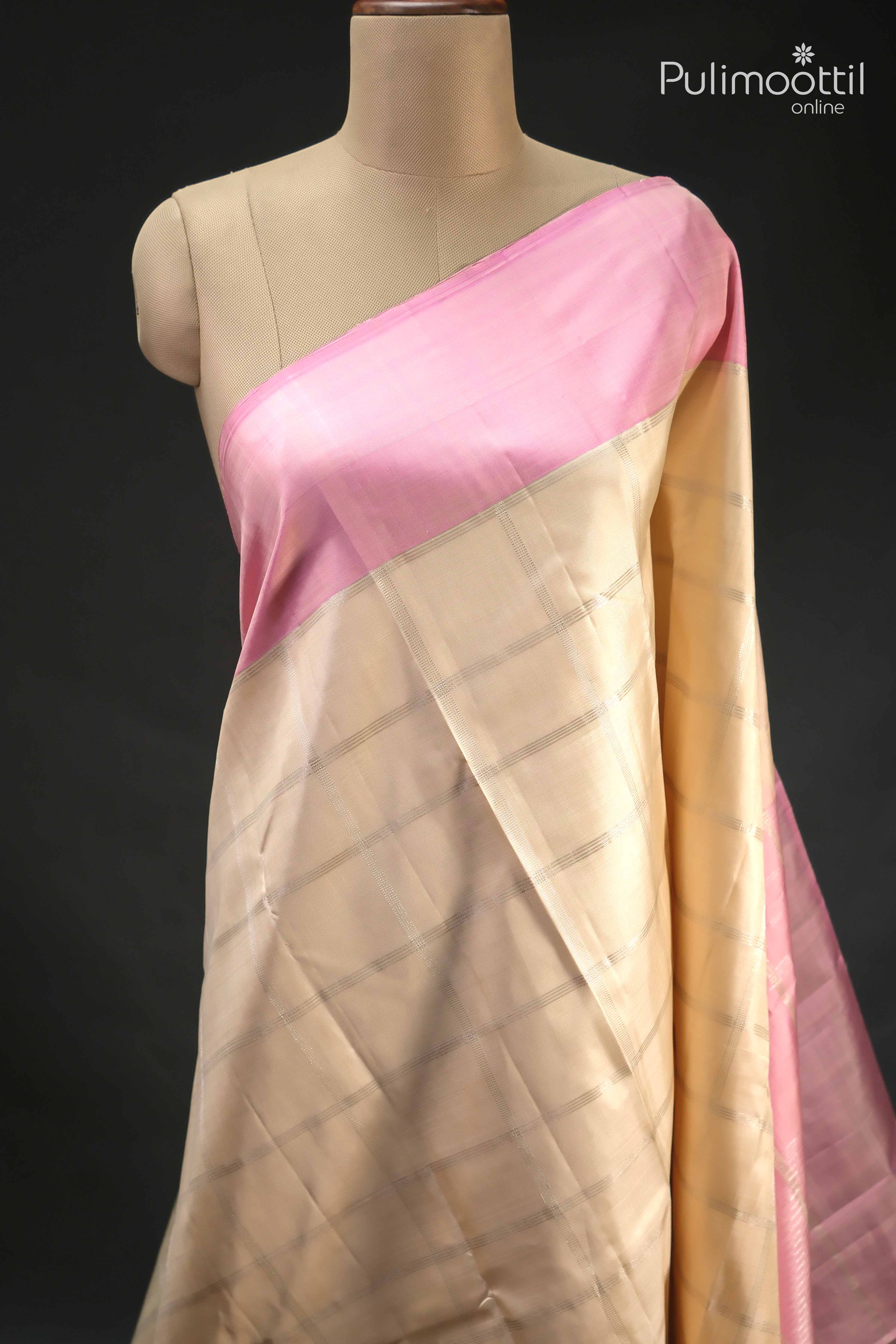 Cream colour pure Kanchipuram silk saree with subtle silver checked design and contrasting soft pink border displayed on a mannequin.