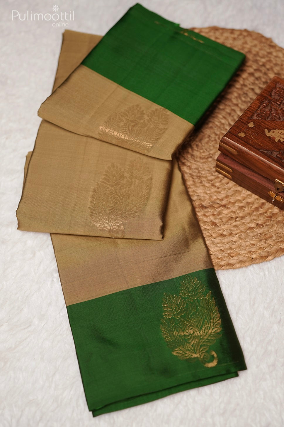 Full view of folded pastel olive green Kanchipuram soft silk saree with golden buttas and contrast green border, elegant choice for wedding and bridal sarees from Pulimoottil Silks Thrissur.