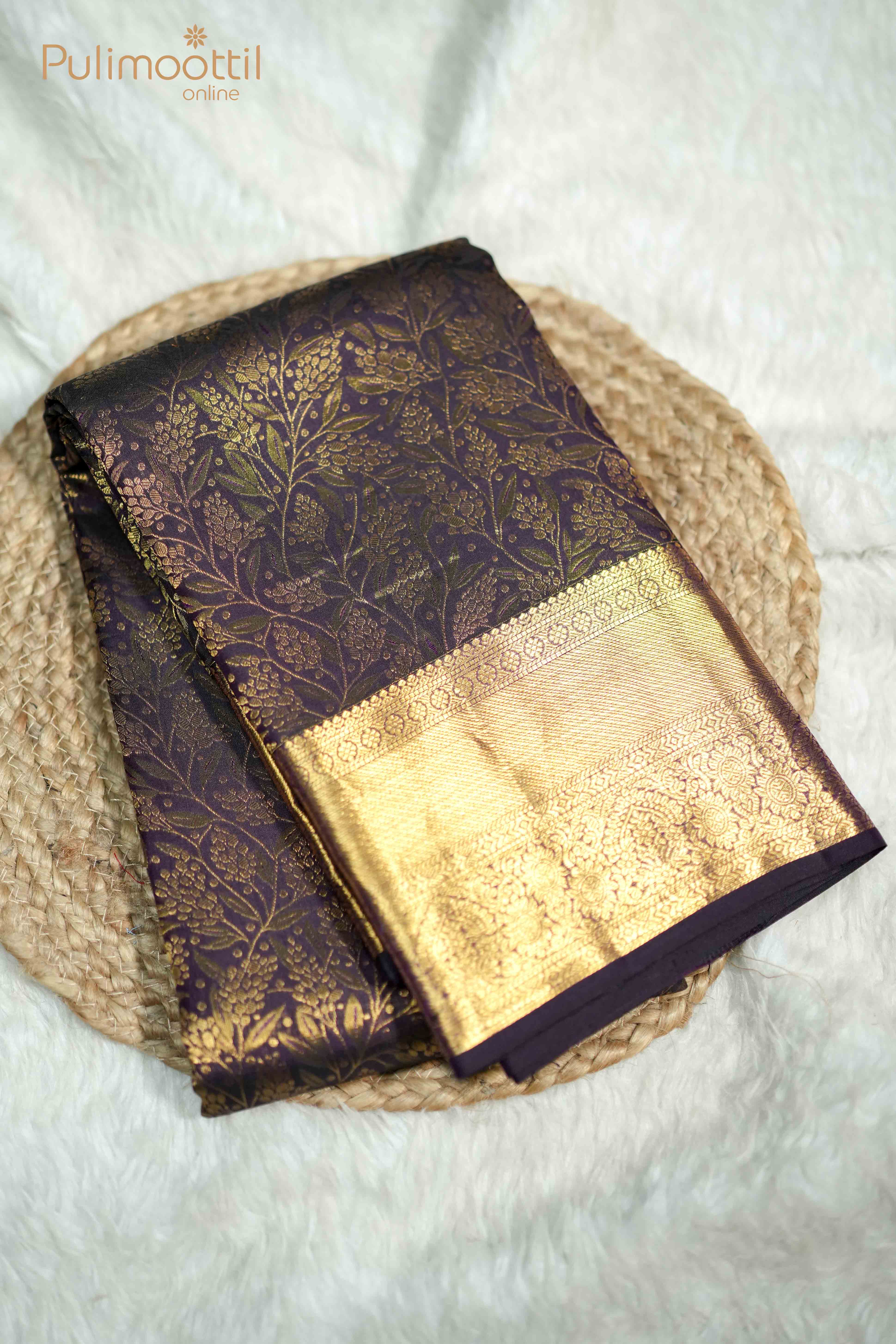 Close-up of Purplle Plum Kanchipuram saree pallu featuring intricate copper zari work with traditional floral and geometric patterns
