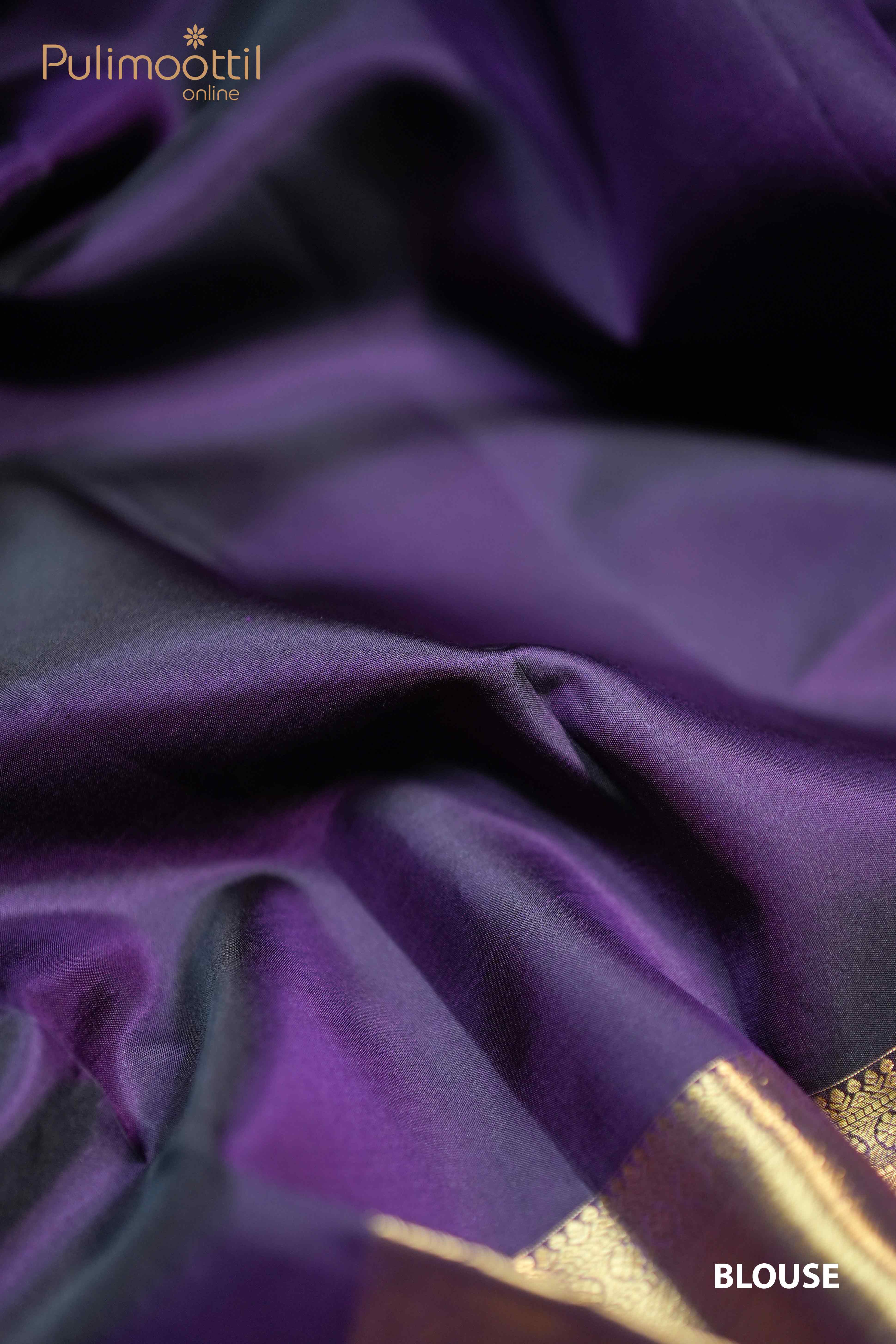 Plain dark purple blouse piece in smooth silk fabric with subtle golden zari border, part of a Kanchipuram wedding saree from Pulimoottil
