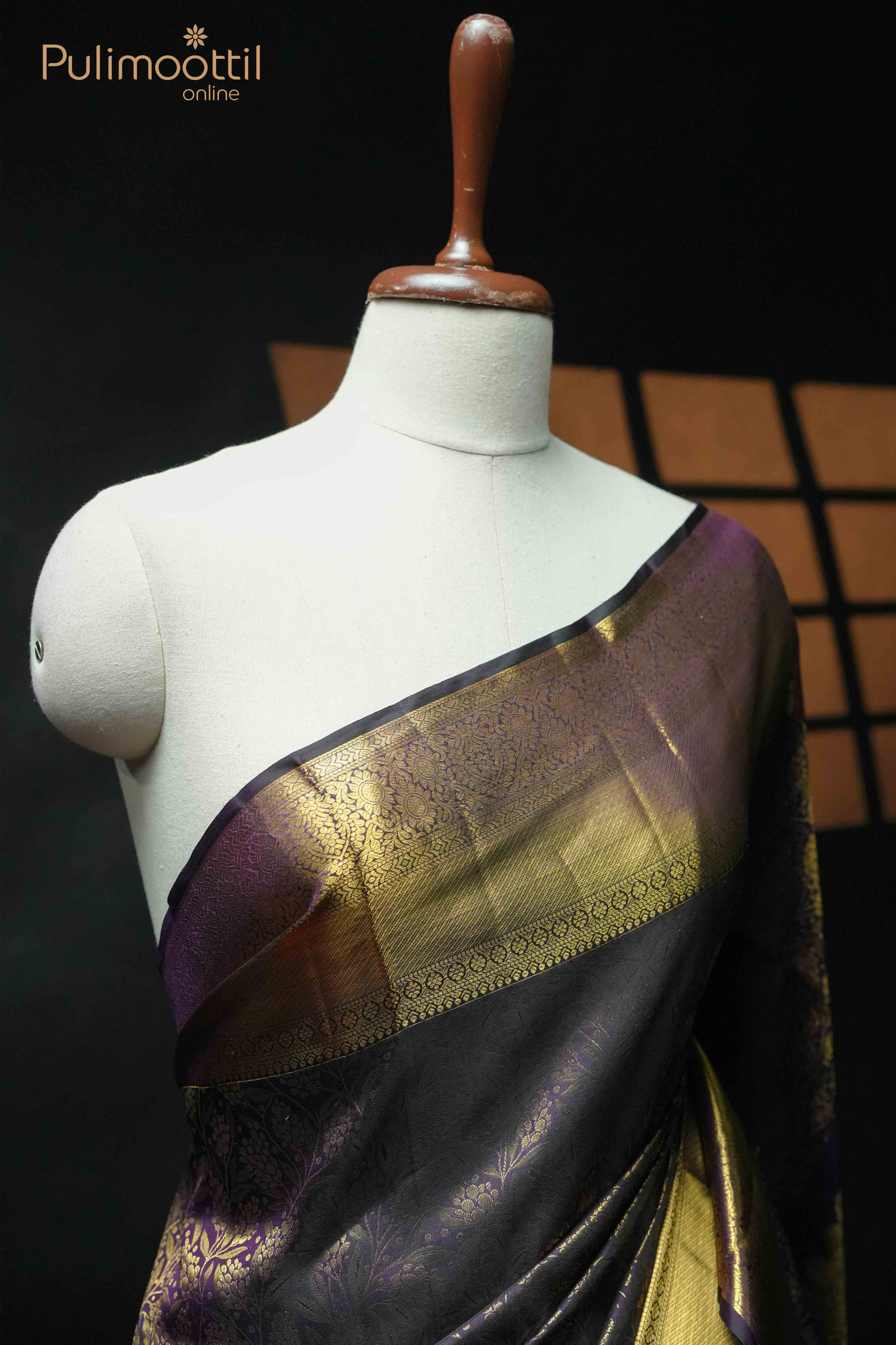 Dark purple Kanchipuram saree with gold floral brocade and traditional border, draped on mannequin.