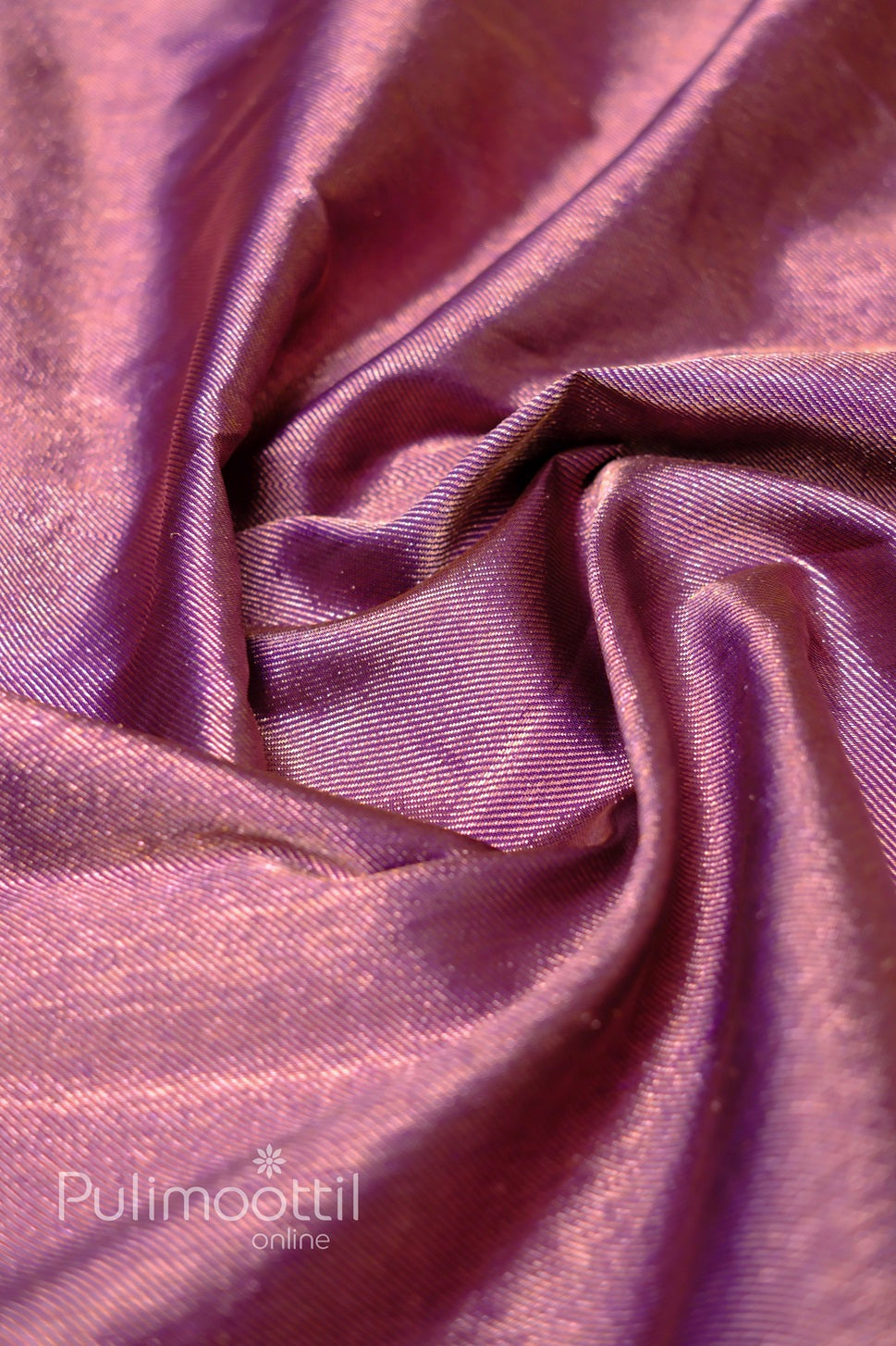 Close-up of dark purple Kanchipuram silk saree body with repeating gold-zari butta motifs.
