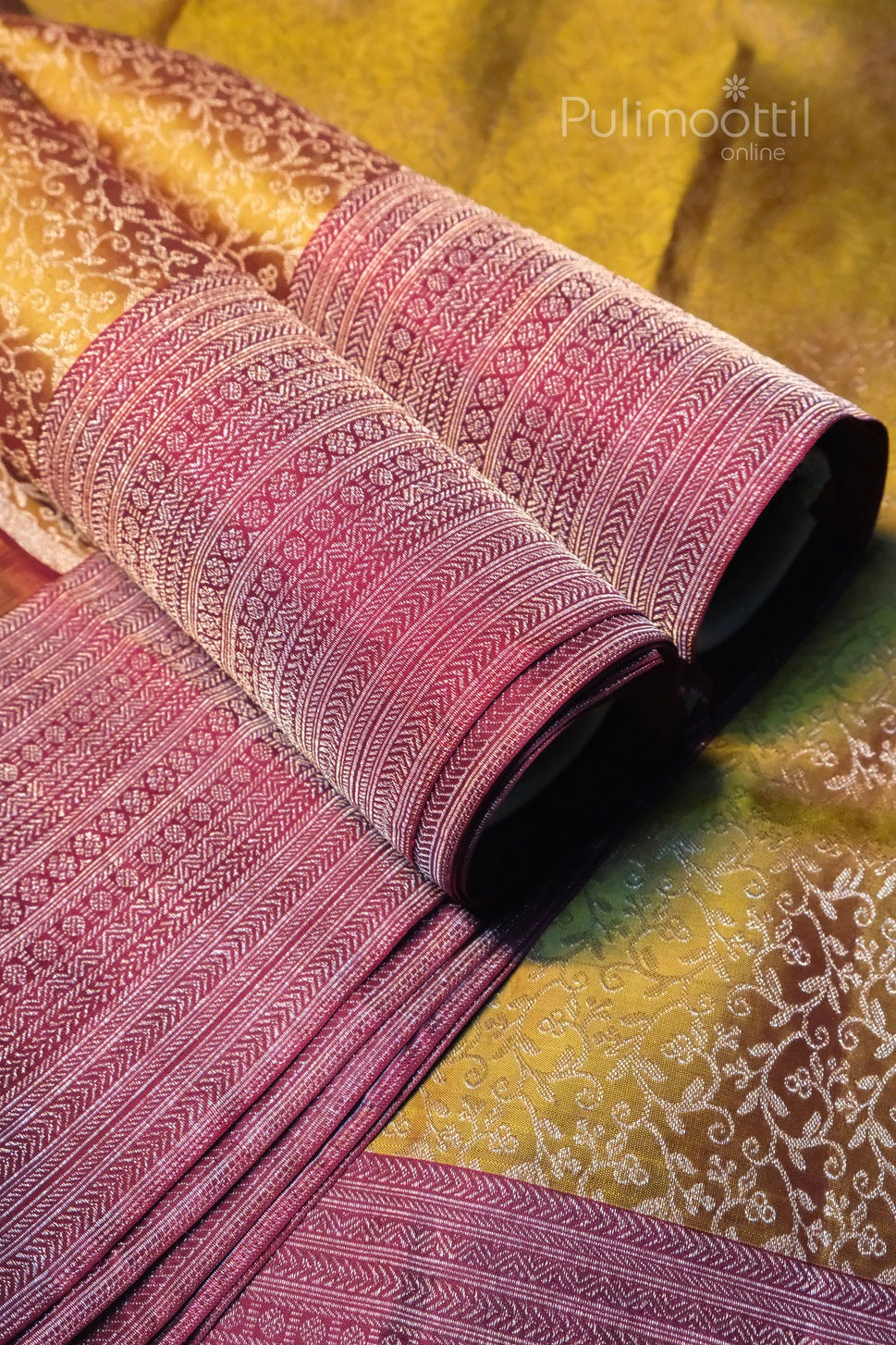 Close-up of Pulimoottil handloom saree showing intricate maroon border weaving on golden silk fabric