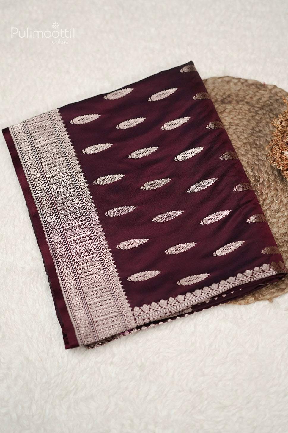 Folded maroon Mashru silk Banarasi saree with golden buttas and detailed designer border, elegant choice for bridal saree and party wear from Pulimoottil Silks Thrissur.