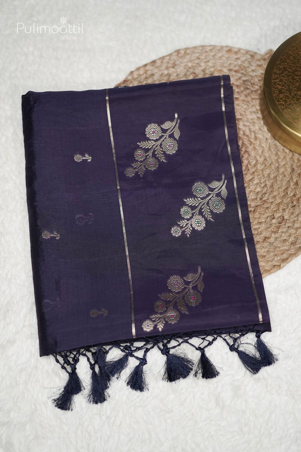 Close-up of dark violet Chiniya silk saree featuring elegant golden floral buttas and intricate floral design border, ideal for bridal saree or party wear occasions.